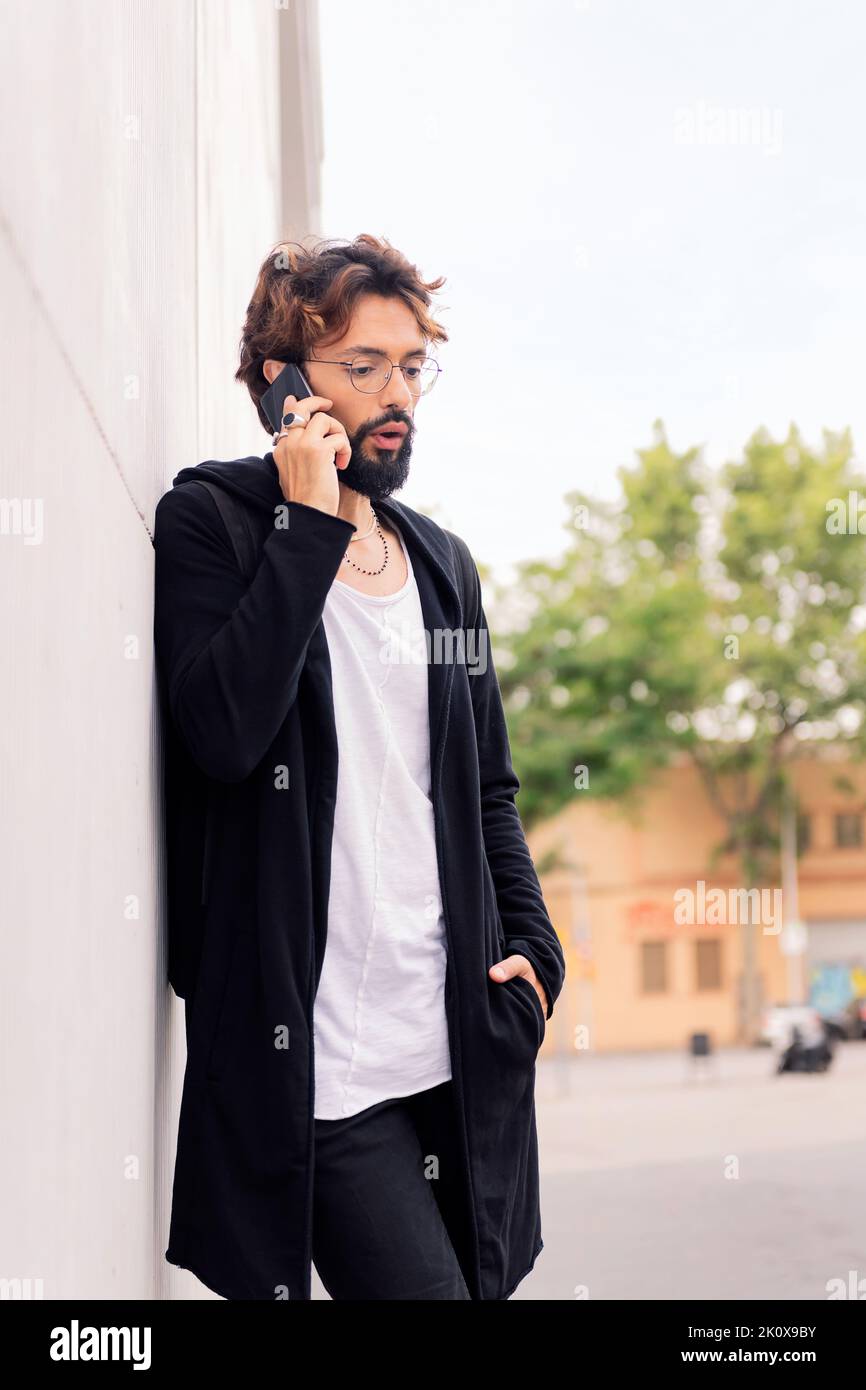 Stilvoller junger Mann, der auf dem Mobiltelefon spricht Stockfoto