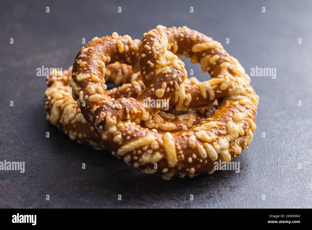 Deutsche Brezel mit gebackenem Käse auf dem Küchentisch. Stockfoto