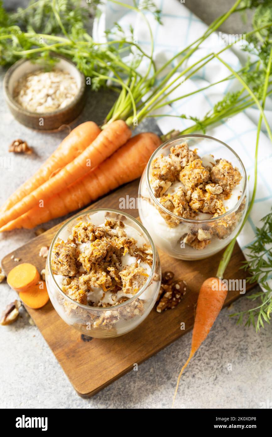 Veganes glutenfreies Backen. Karottenkuchen mit Walnüssen und Zimt in einem Glas auf hellem Hintergrund. Gesundes Dessert. Stockfoto