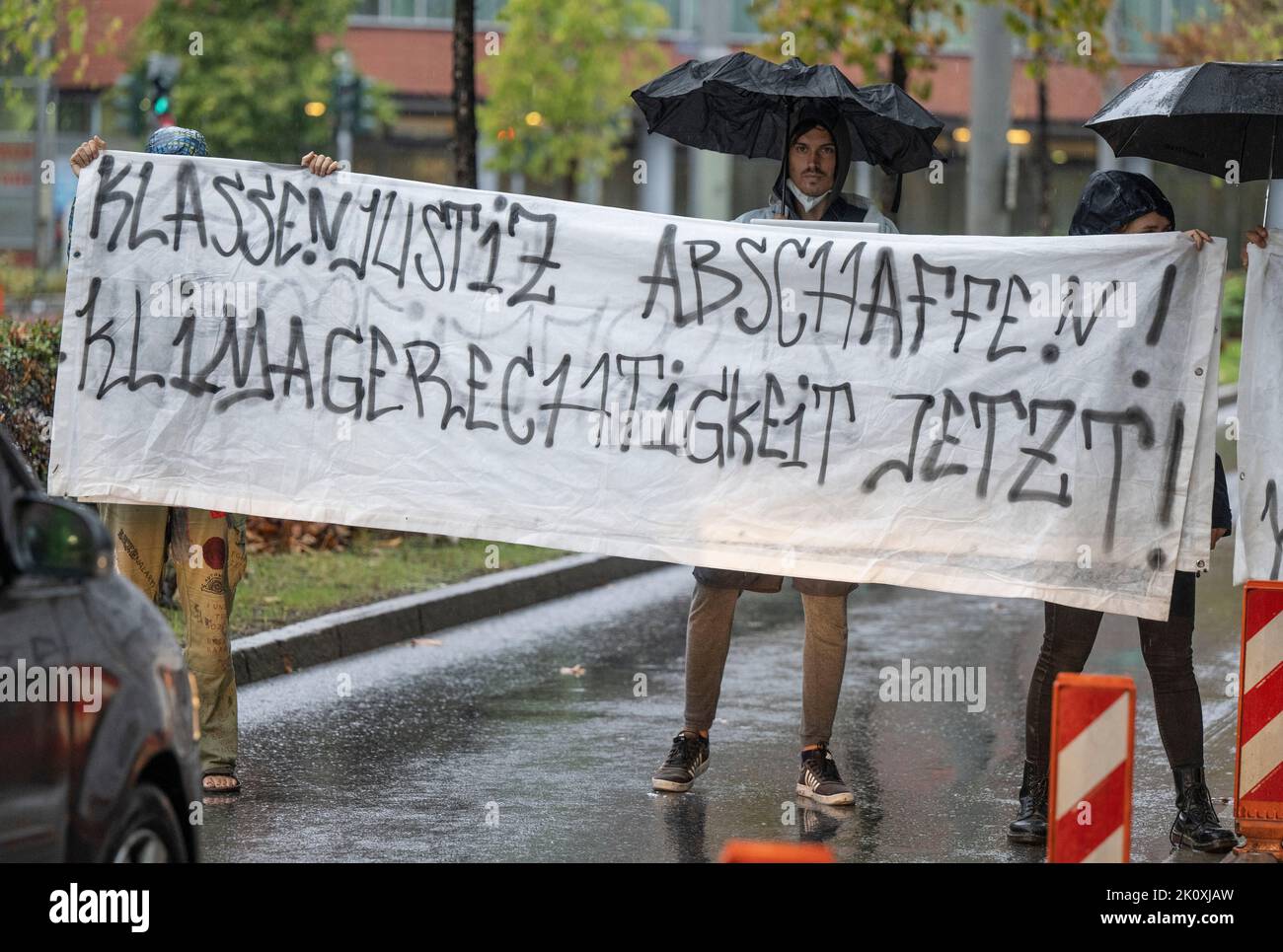 14. September 2022, Hessen, Frankfurt/Main: Klassenjustiz abschaffen! Klimagerechtigkeit jetzt!“ Steht auf einem Plakat, mit dem einige Demonstranten vor dem Frankfurter Gericht protestieren. Hintergrund der Aktion war ein inzwischen abgekündigter Prozess gegen Klimaaktivisten, die sich von Autobahnbrücken abseilten. Foto: Boris Roessler/dpa Stockfoto