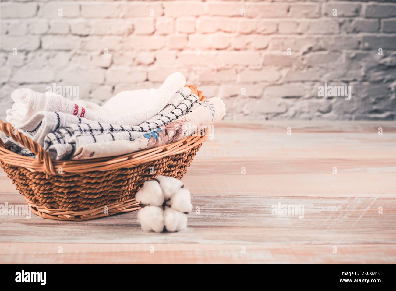 Ein Stapel Bio-Küchentücher in einem Korb mit Baumwollblume. Konzept der Nachhaltigkeit. Stockfoto