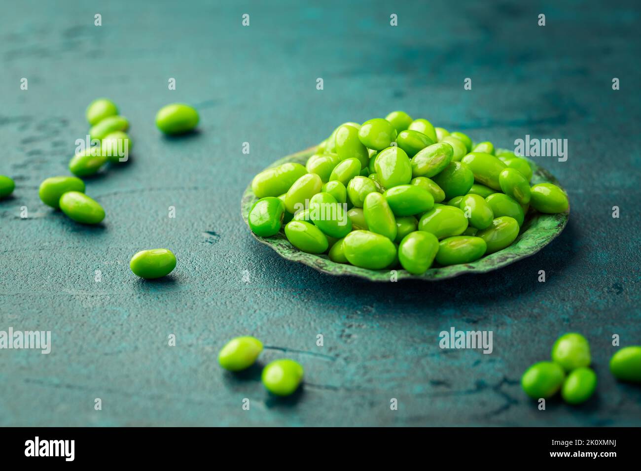 Schüssel mit rohen Edamamabohnen auf cyanfarbenem Hintergrund Stockfoto