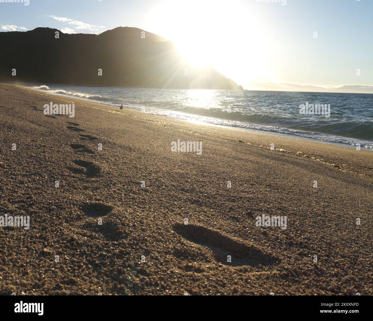 Fußabdrücke am Strand im Sonnenuntergang Stockfoto