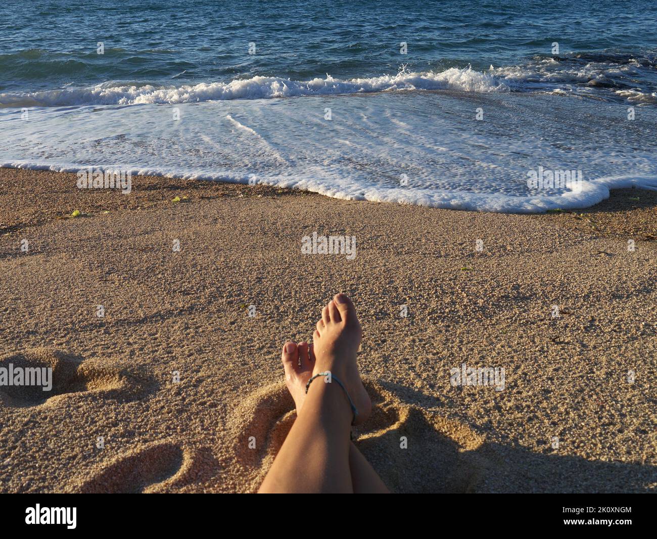 Füße im Sand am Strand Stockfoto