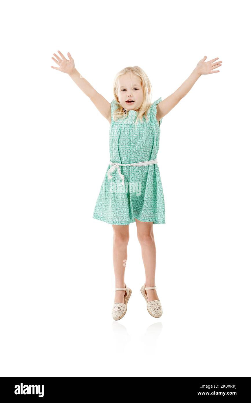 Greifen Sie nach dem Himmel. Studioaufnahme eines niedlichen kleinen Mädchens, das vor Freude vor weißem Hintergrund springt. Stockfoto