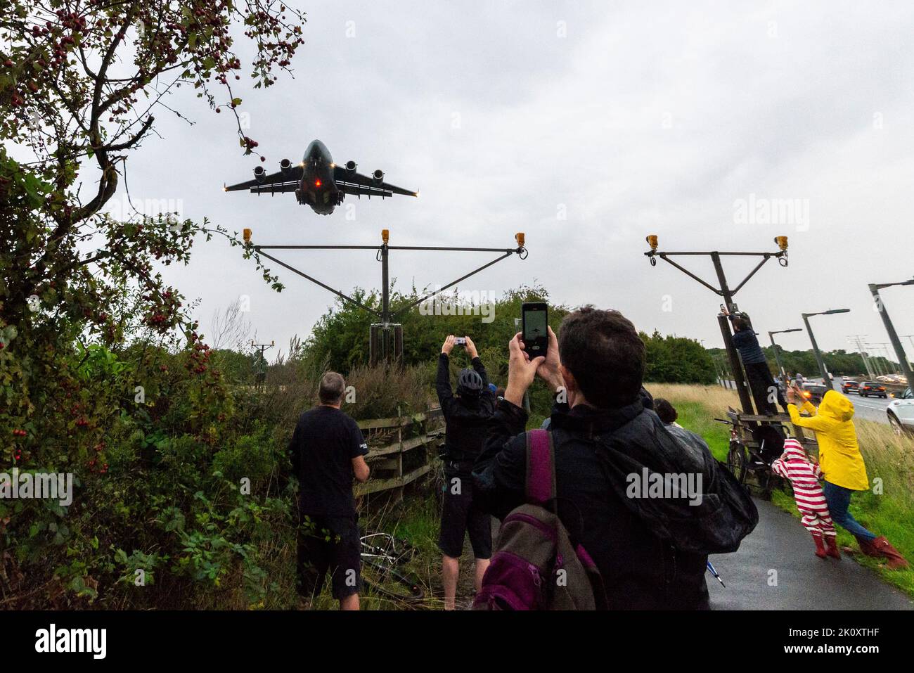 Transportflugzeug der Royal Air Force C-17 Globemaster, das den Körper der Queen trägt und von Edinburgh aus in RAF Northolt, London, Großbritannien, landet. Menschenmengen beobachten Stockfoto