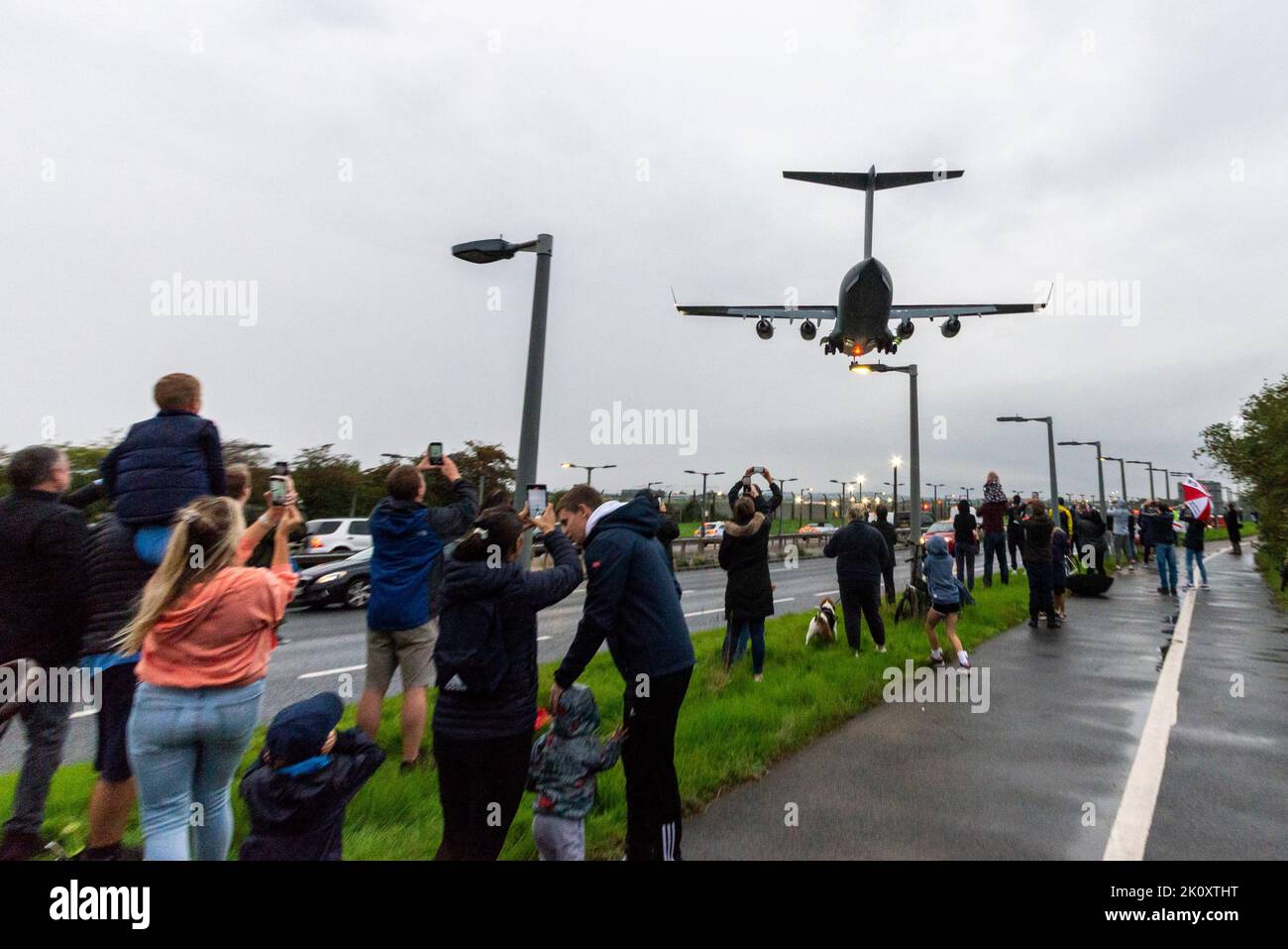 Transportflugzeug der Royal Air Force C-17 Globemaster, das den Körper der Queen trägt und von Edinburgh aus in RAF Northolt, London, Großbritannien, landet. Menschenmengen beobachten Stockfoto