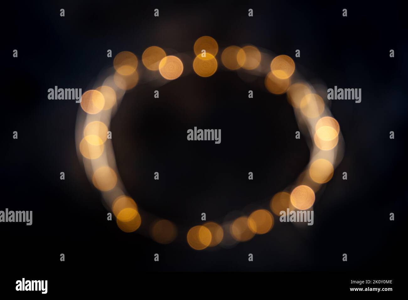 Lichterketten, LED-Girlande, verschwommenes Flachbild mit Bokeh auf schwarzem Hintergrund. Abstrakter Weihnachtsrahmen mit Platz für Text Stockfoto