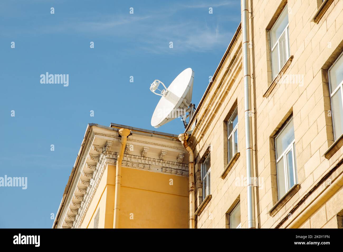 Große Satellitenschüssel oder Satellitenantenne auf dem Gebäudedach. Sonniger Tag. Stockfoto