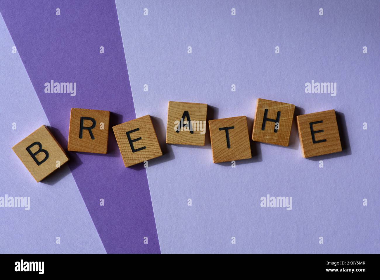 Atmen, Wort in hölzernen Buchstaben Alphabet isoliert auf violettem Hintergrund Stockfoto