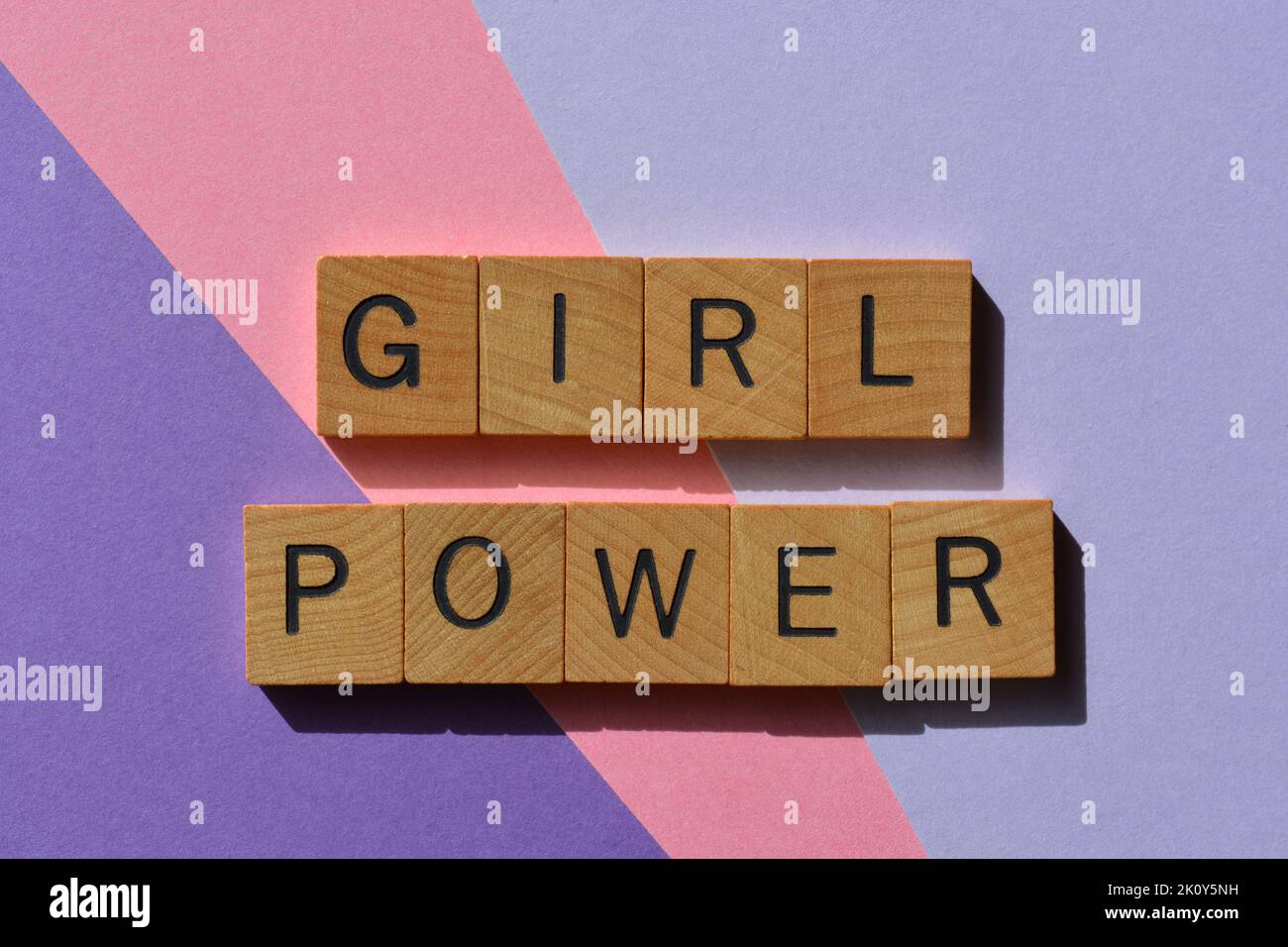 Girl Power, Wörter in Holzbuchstaben isoliert auf rosa und lila Hintergrund Stockfoto