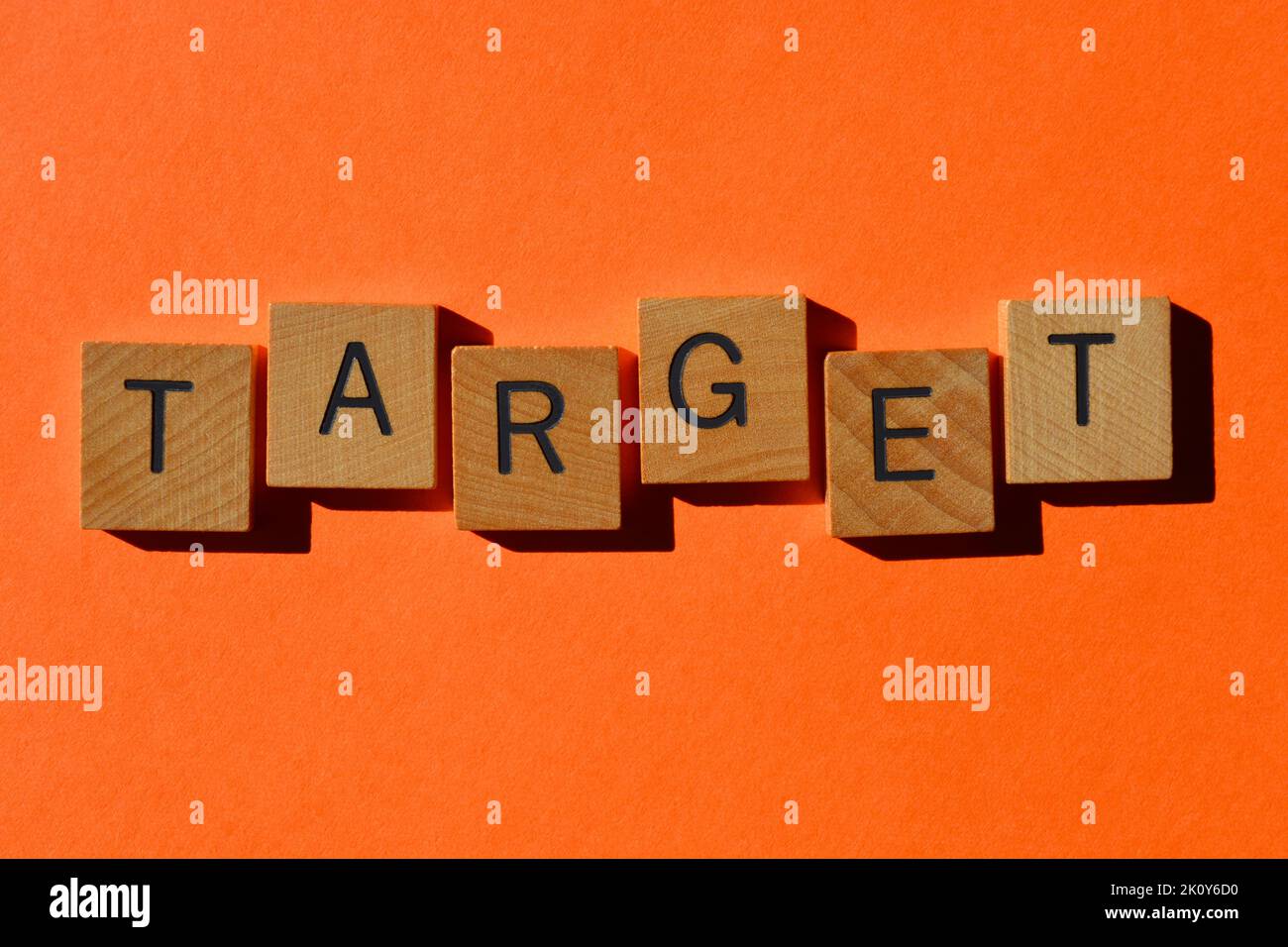 Ziel, Wort in hölzernen Buchstaben auf orangefarbenem Hintergrund isoliert Stockfoto
