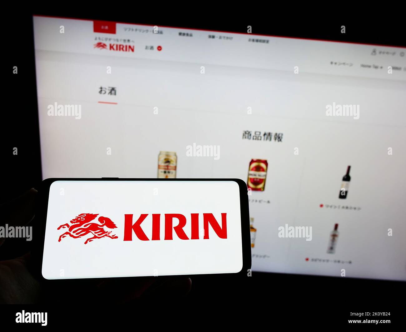 Person, die ein Smartphone mit dem Logo der japanischen Kirin Brewery Company Limited auf dem Bildschirm vor der Website hält. Konzentrieren Sie sich auf die Telefonanzeige. Stockfoto