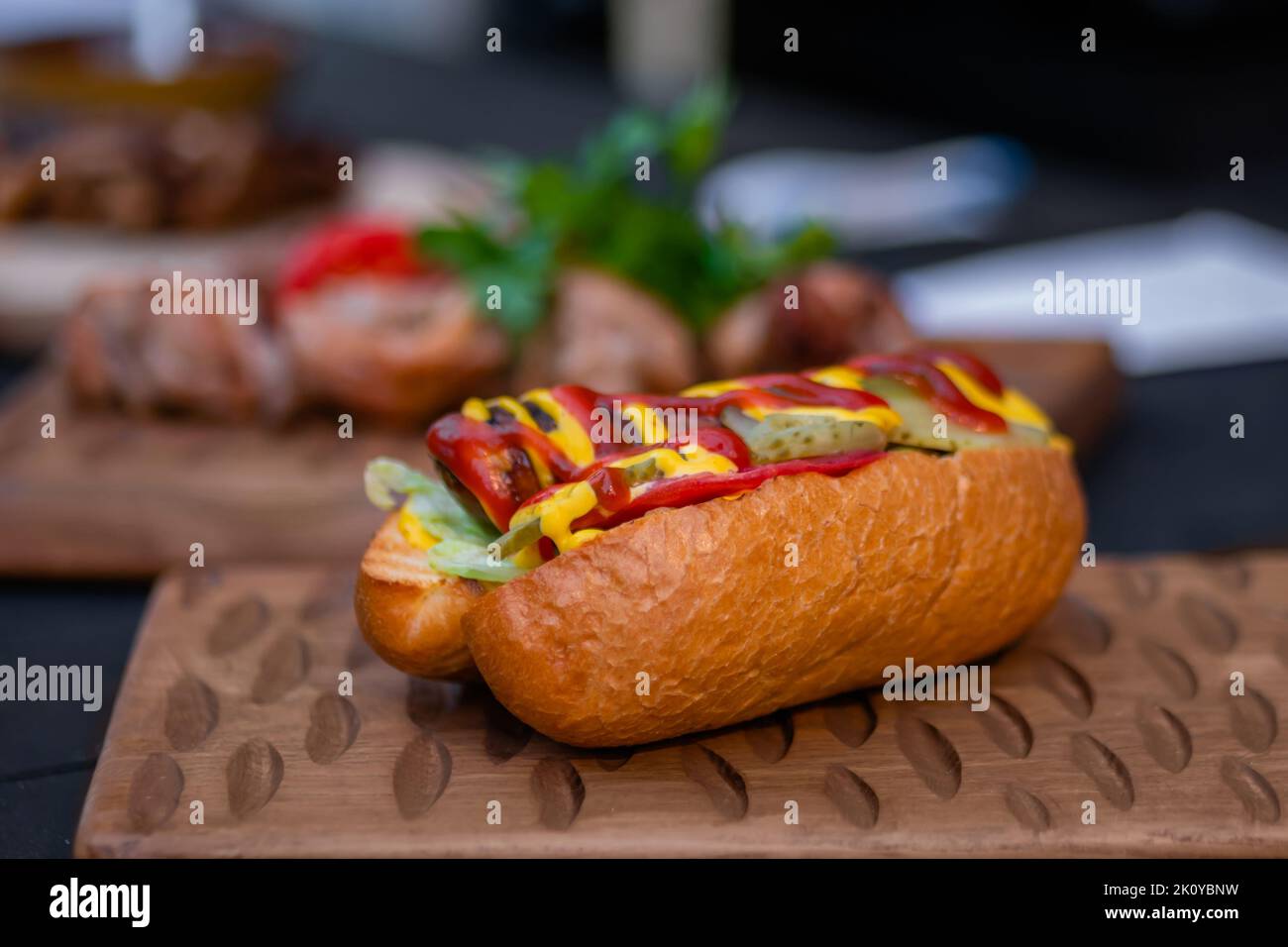 Hot Dog mit Wurst und Sause Ketchup auf Holzbrett beim Street Food Festival Stockfoto