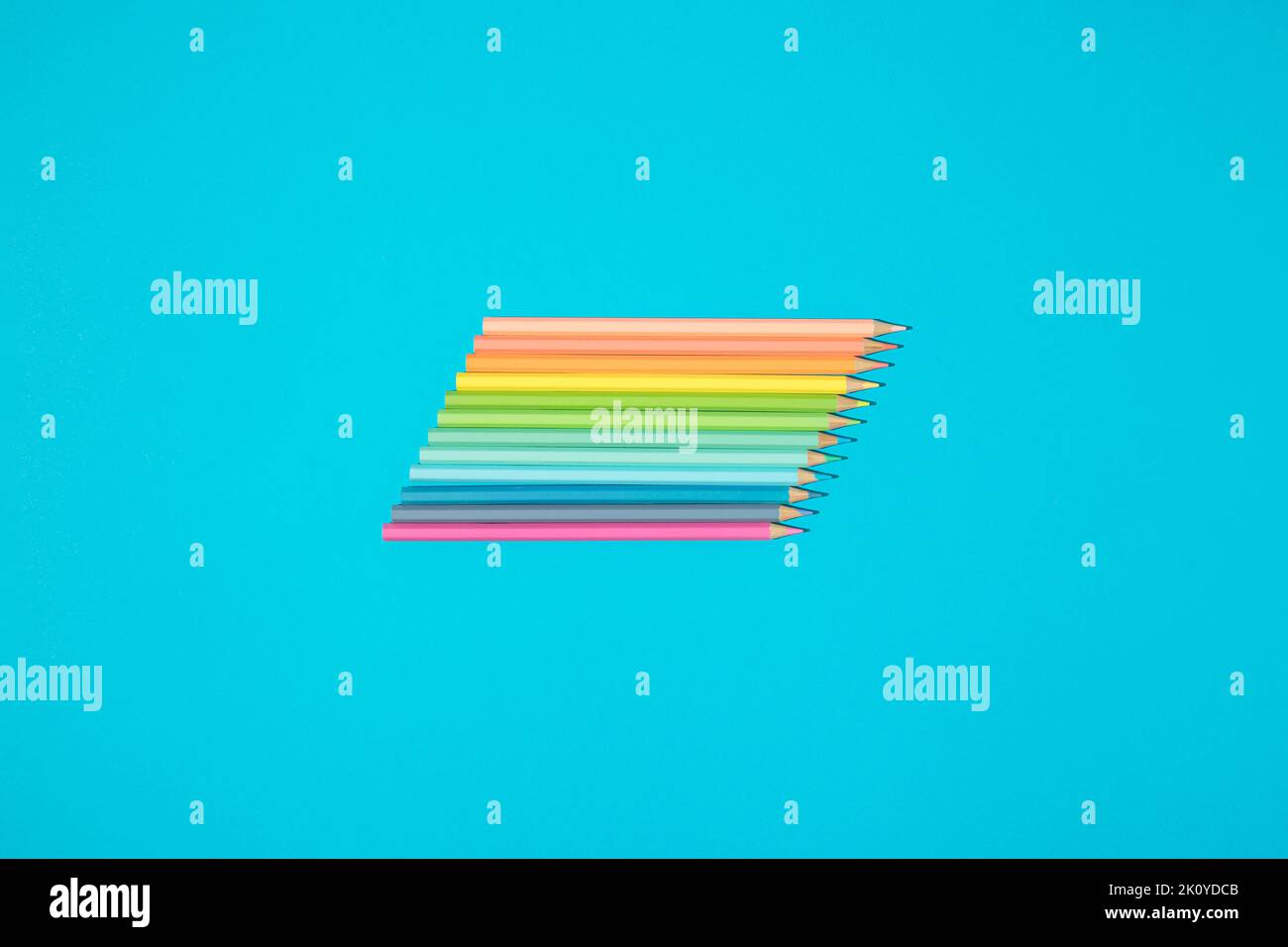 Regenbogen Palette Malstifte auf blauem Hintergrund. Kunst und Schulbedarf. Stockfoto