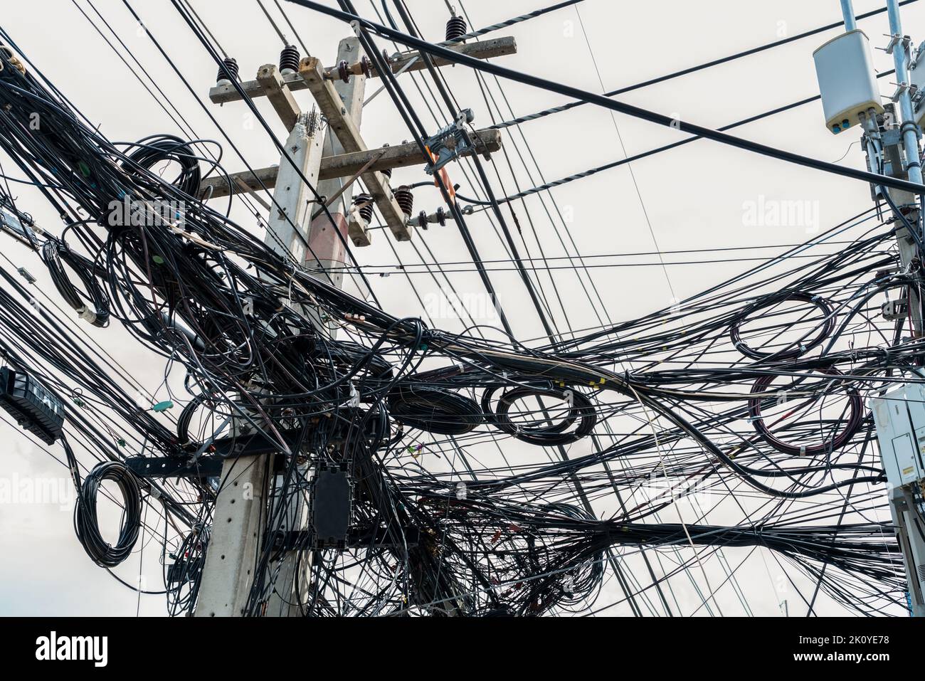 Verworrene elektrische Drähte auf dem städtischen Strommast. Unorganisiert und chaotisch zu Organisationsmanagement-Konzept. Nahaufnahme verwickelte elektrische Leitungen Stockfoto