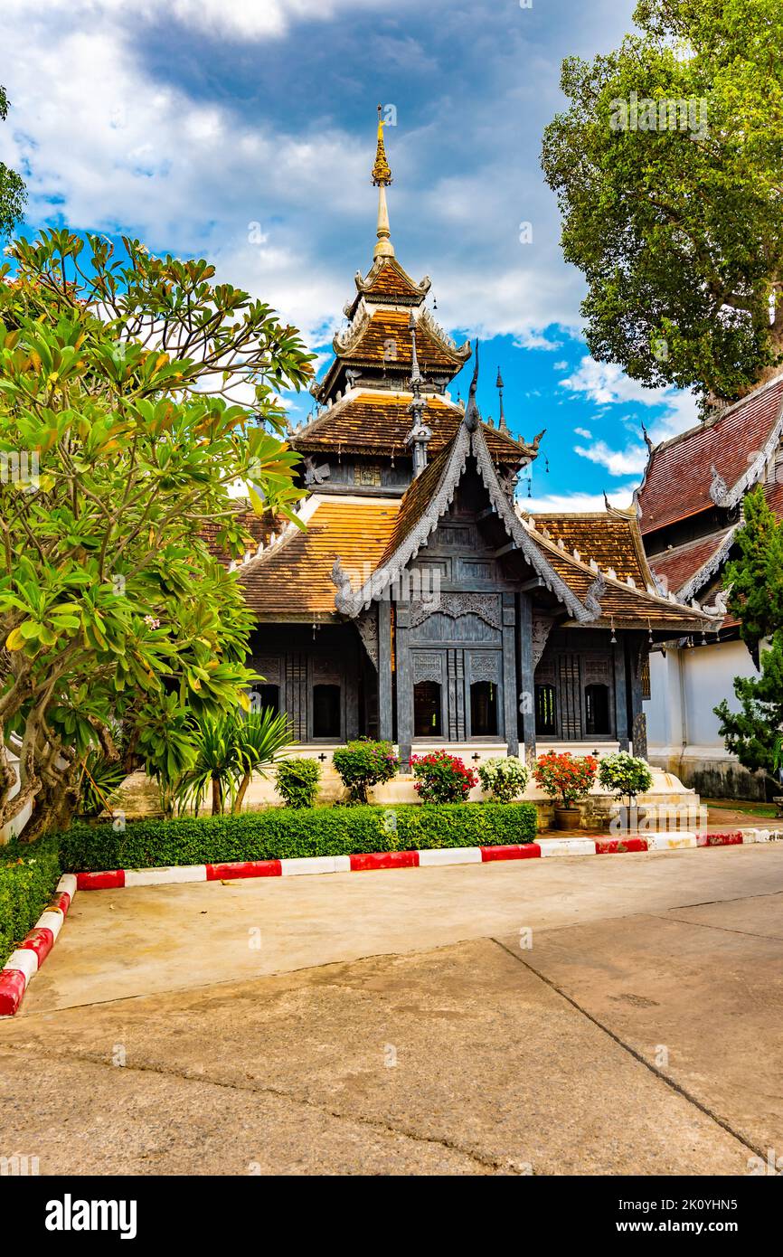 Hölzerner Pagodentempel in der Nähe des Wat Chedi Luang Tempels in Chiang Mai, Thailand. Buddhistischer spiritueller Ort, altes Gebäude. Formeller Garten vor dem Haus, Stockfoto