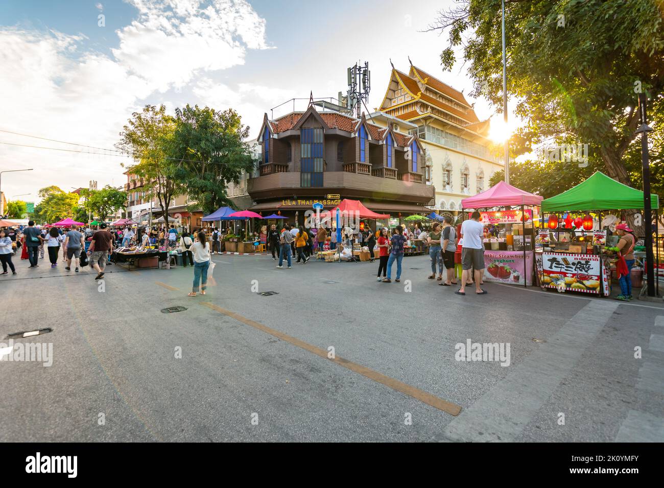 CHIANG MAI, THAILAND - 3.11.2019: Nachtmarkt in der Stadt Chiang Mai kurz nach Sonnenuntergang. Touristen gehen auf der Straße. Thailändische Verkäufer im Stall Stockfoto