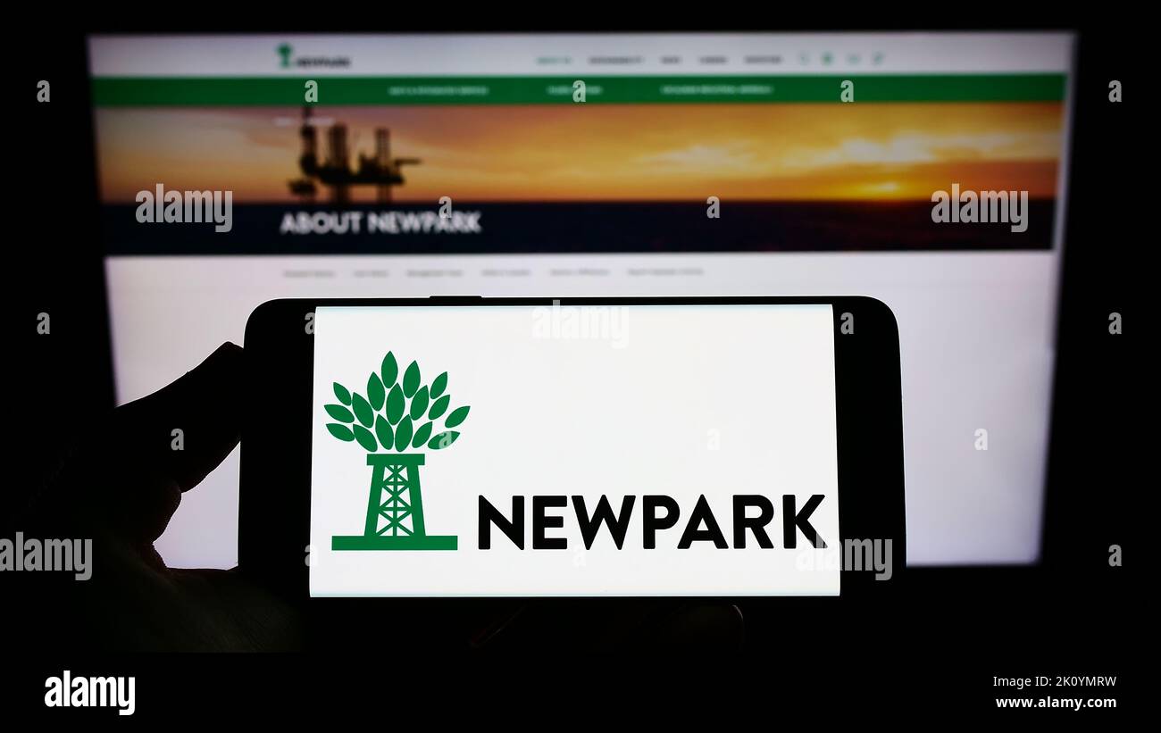 Person, die das Smartphone mit dem Logo des Bohrsystemunternehmens Newpark Resources Inc. Auf dem Bildschirm vor der Website hält. Konzentrieren Sie sich auf die Telefonanzeige. Stockfoto