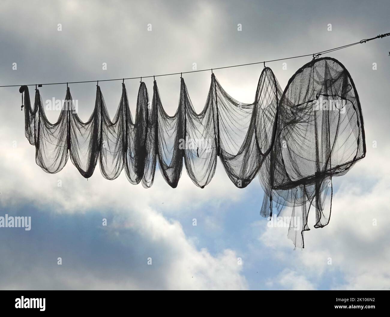 Ein Fischernetz (Reifennetz oder Fyke), das an einem Kabel hängt. Diese Netze werden in Elburg, Niederlande, zur Verschönerung der Hauptstraße eingesetzt Stockfoto