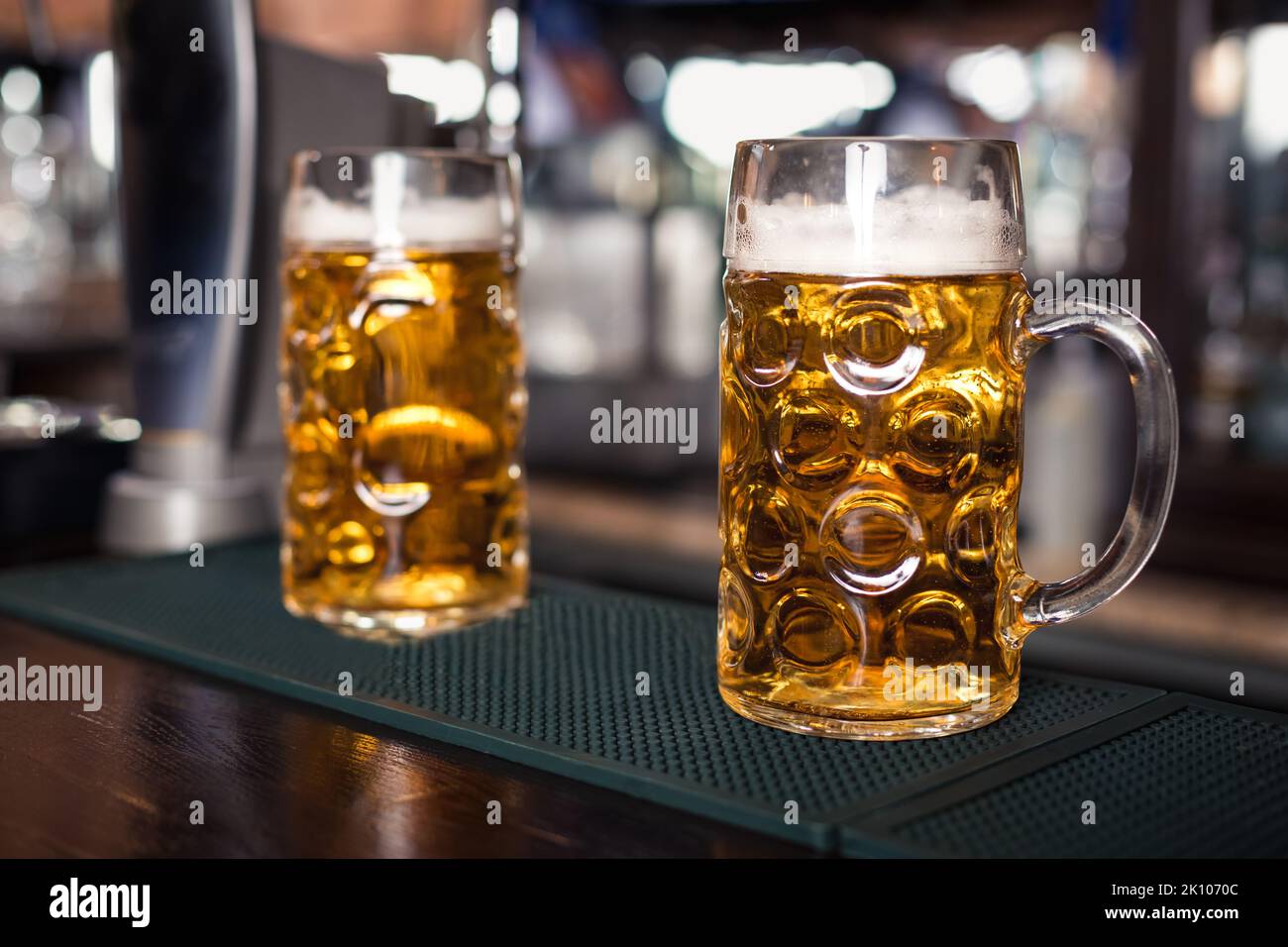 Zwei Gläser Bier auf einem Bartisch. Bierzapfen im Hintergrund Stockfoto
