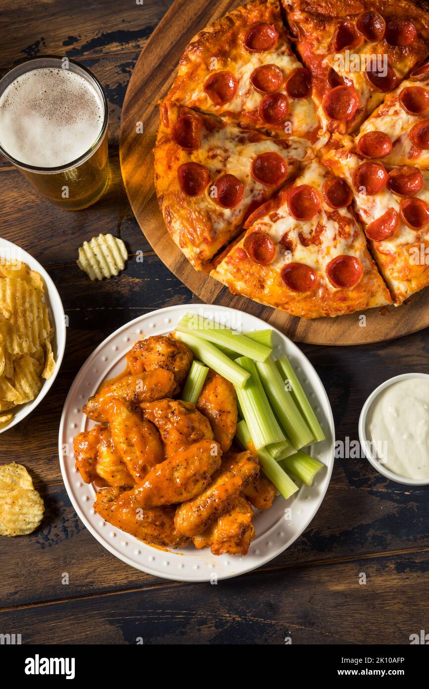 Hausgemachte Pepperoni Pizza Chicken Wings und Bier für eine Fußballparty Stockfoto