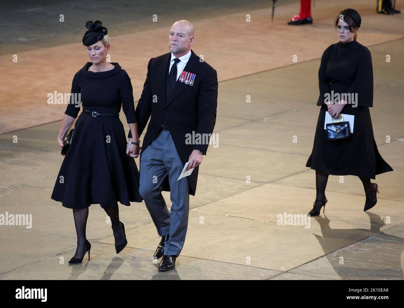 Zara und Mike Tindall und Prinzessin Eugenie gehen, als der Sarg von Königin Elizabeth II., der im Royal Standard mit der Kaiserlichen Staatskrone oben drapiert ist, in der Westminster Hall, London, ankommt, wo er vor ihrer Beerdigung am Montag im Zustand liegen wird. Bilddatum: Mittwoch, 14. September 2022. Stockfoto