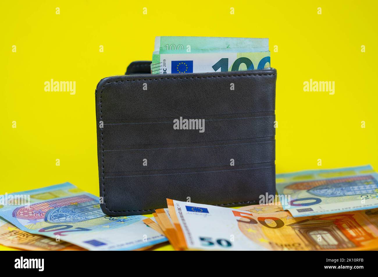 Etui aus echtem Leder mit Euro-Banknoten innen isoliert auf gelbem Hintergrund. Stockfoto