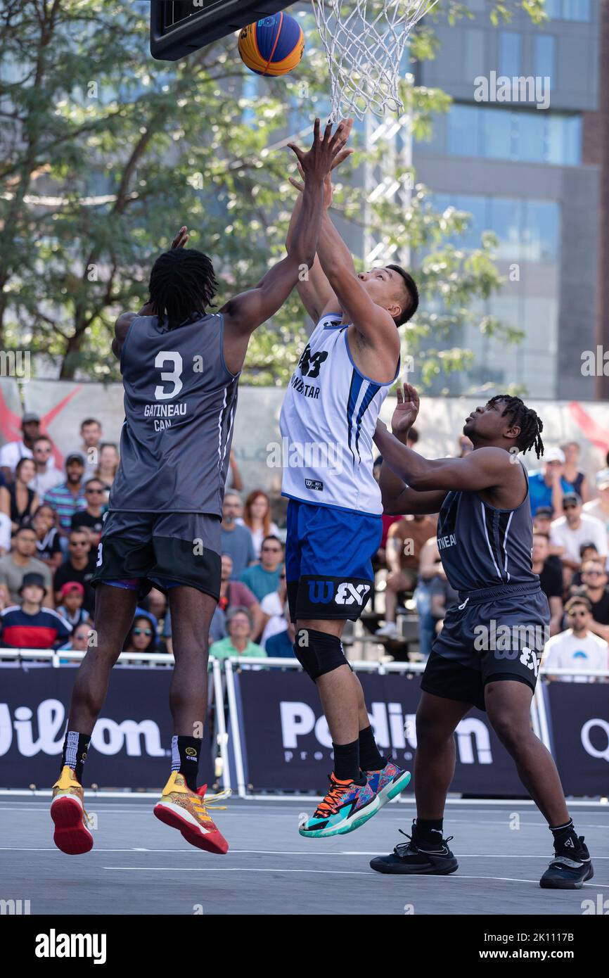 Montreal, Kanada, 03. September 2022: Delgernyam Davaasambuu (weiß) vom Team Ulaanbaatar MMC Energy of Mongolia tritt beim Poollauf der 2022 FIBA 3x3 World Tour Montreal Masters auf dem Place des Festivals in Montreal, Kanada, gegen Anthony Tsegakele (grau, links) und Alain Bernard Louis (grau, rechts) vom Team Gatineau aus Kanada an. Das Team Ulaanbaatar MMC Energy of Mongolia gewann das Spiel mit 21:16 Punkten. Stockfoto