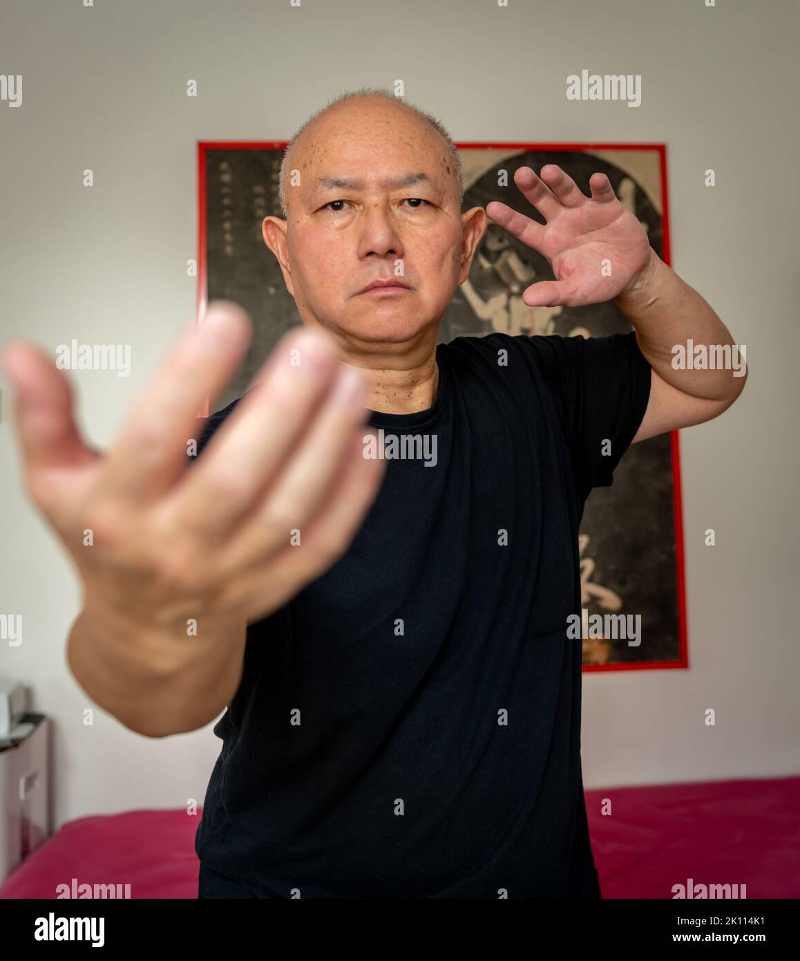 Ein älterer Mann, der in der Halle die Kampfkunst übt. Stockfoto