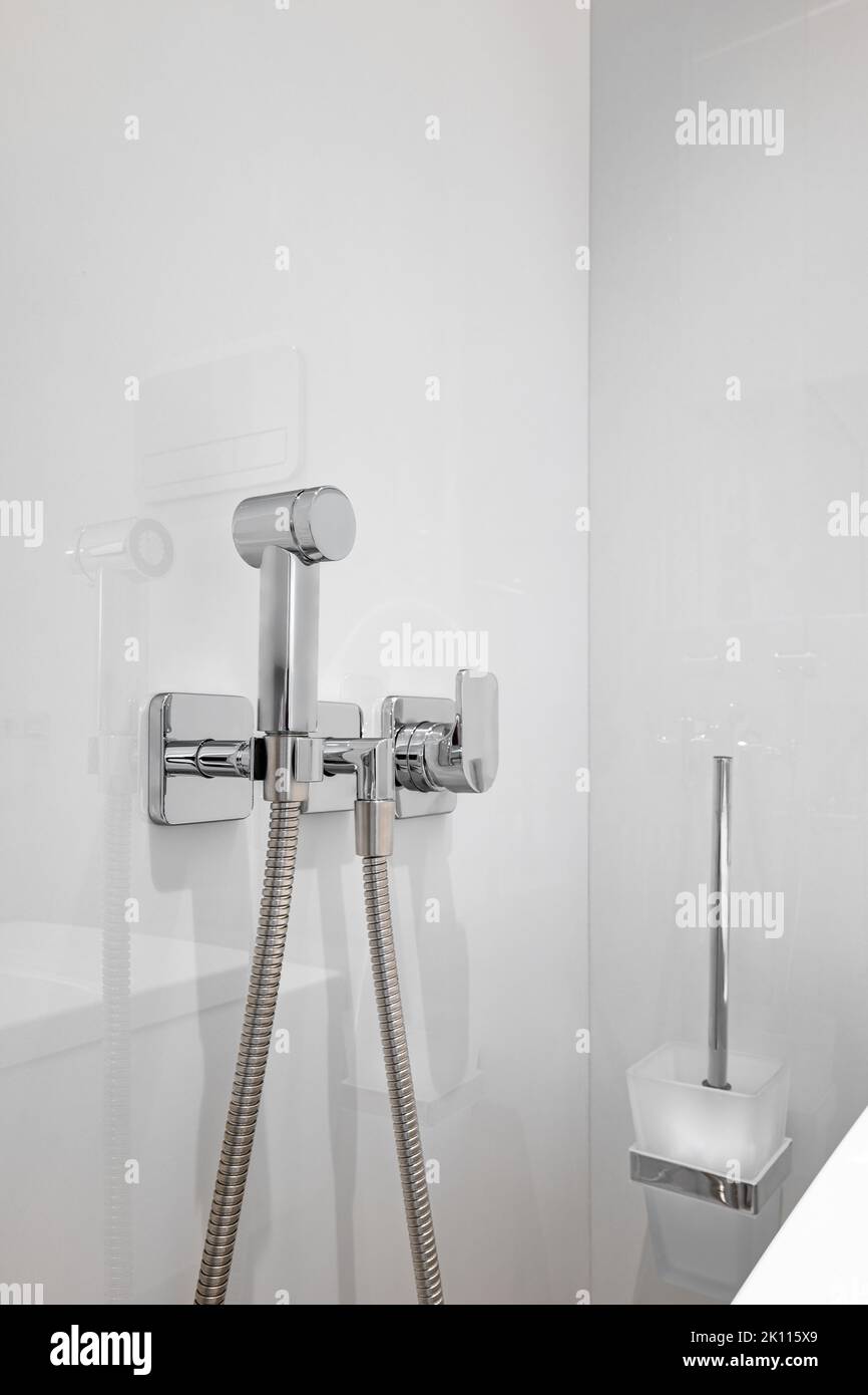 Nahaufnahme der Chrom-Bidet-Dusche in einer Toilette. Vertikale Aufnahme der sauberen und neuen Sprühdusche. Stockfoto
