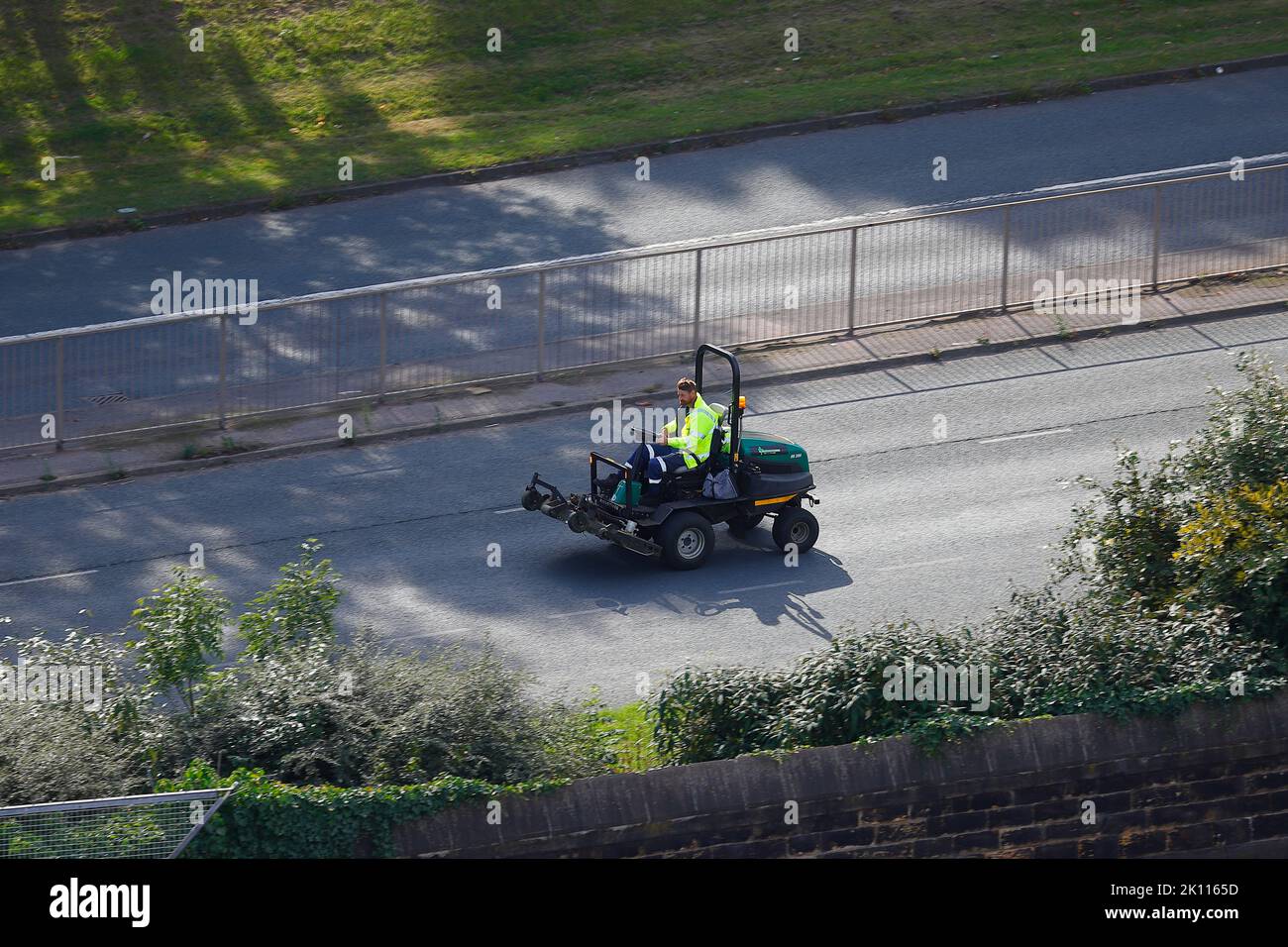 Ein Mitarbeiter von Leeds City Council Parks & Gardens, der auf einer Fahrt auf der Armley Road in Leeds, West Yorkshire, Großbritannien, auf einem Mäher gesehen wurde Stockfoto