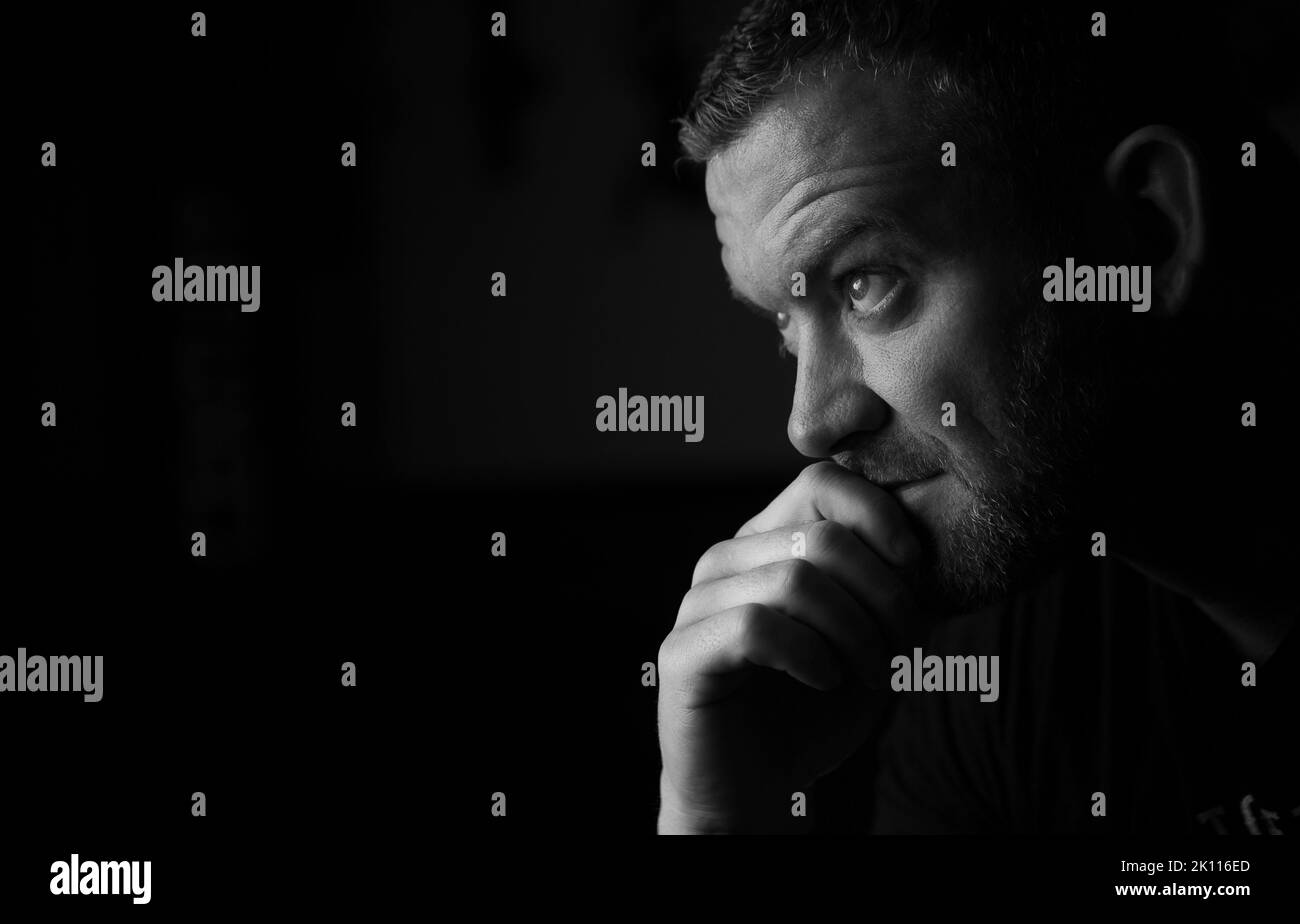 Seitenkopffoto eines Mannes, der einen denkenden Ausdruck gibt. Stockfoto