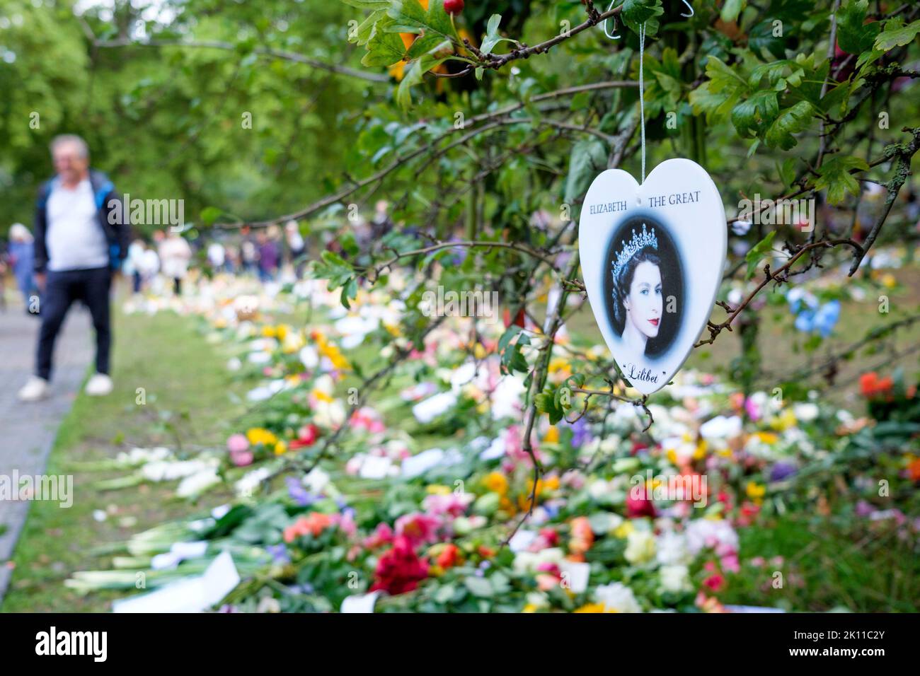 London, Großbritannien. 14. September 2022. Als Menschenmassen nach London kamen, um zu beobachten, wie der Sarg Ihrer Majestät der Königin zum Palace of Westminster transportiert wurde, werden die Menschen beim Anblick der Blumenkarten, Bären und anderer Ehrungen, die im Green Park, London, hinterlassen wurden, abgebildet. Quelle: Lynchpics/Alamy Live News Stockfoto