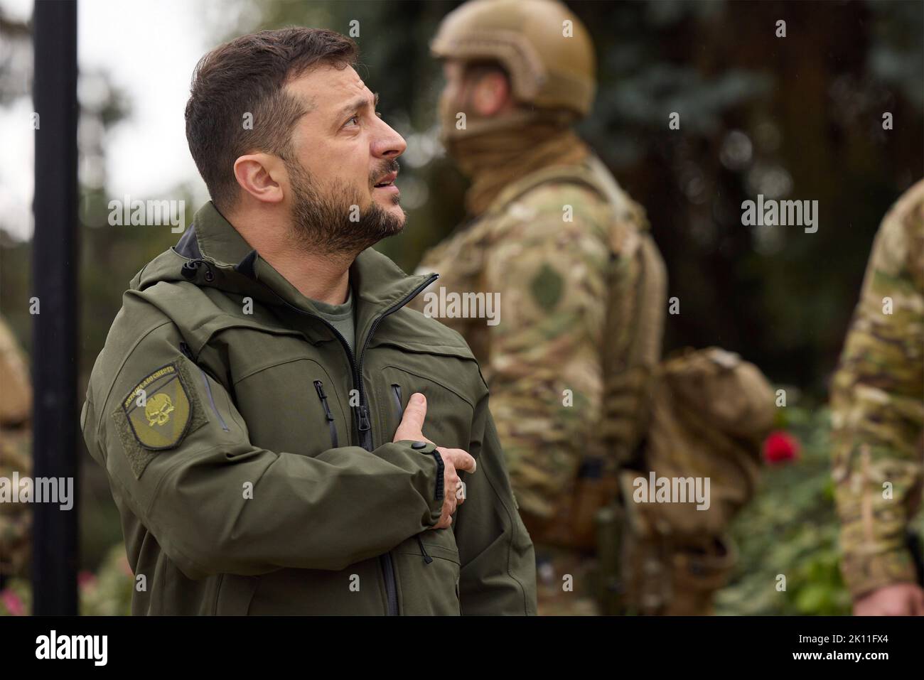 Izium, Ukraine. 14. September 2022. Der ukrainische Präsident Wolodymyr Zelenskyy, links, begrüßt, als die ukrainische Flagge über der zurückerobert Stadt während einer Zeremonie vor dem beschädigten Rathaus am 14. September 2022 in Izium, Region Charkiw, Ukraine, angehoben wird. Zelenski machte einen überraschenden Besuch in der Stadt, die während einer ukrainischen Gegenoffensive aus Russland zurück erobert wurde. Kredit: Ukrainisches Presidential Press Office/Ukraine Presidency/Alamy Live News Stockfoto