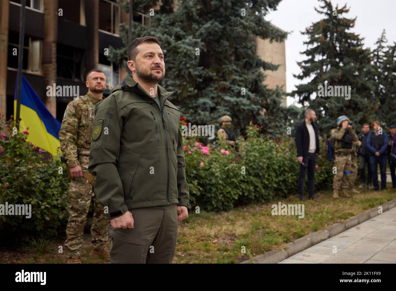 Izium, Ukraine. 14. September 2022. Der ukrainische Präsident Wolodymyr Zelenskyy, links, steht während einer Zeremonie vor dem beschädigten Rathausgebäude am 14. September 2022 in Izium, Region Charkiw, Ukraine, während die ukrainische Flagge über der zurückerobert wurde. Zelenski machte einen überraschenden Besuch in der Stadt, die während einer ukrainischen Gegenoffensive aus Russland zurück erobert wurde. Kredit: Ukrainisches Presidential Press Office/Ukraine Presidency/Alamy Live News Stockfoto