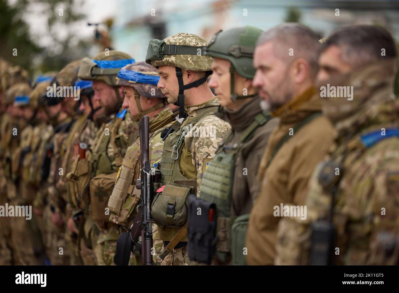 Izium, Ukraine. 14. September 2022. Ukrainische Soldaten stehen während einer Zeremonie mit Präsident Wolodymyr Zelenskyy vor dem ausgebrannten Rathaus am 14. September 2022 in Izium, Region Charkiw, Ukraine, für einen Moment des Schweigens zu Ehren der Gefallenen. Zelenski machte einen überraschenden Besuch in der Stadt, die während einer ukrainischen Gegenoffensive aus Russland zurück erobert wurde. Kredit: Ukrainisches Presidential Press Office/Ukraine Presidency/Alamy Live News Stockfoto