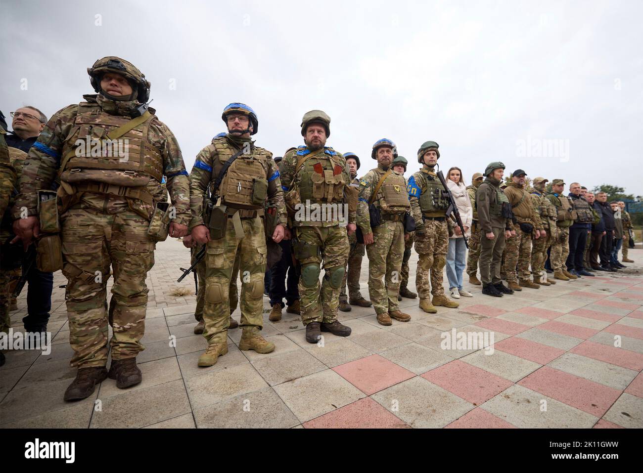 Izium, Ukraine. 14. September 2022. Ukrainische Soldaten stehen während einer Zeremonie mit Präsident Wolodymyr Zelenskyy vor dem ausgebrannten Rathaus am 14. September 2022 in Izium, Region Charkiw, Ukraine, für einen Moment des Schweigens zu Ehren der Gefallenen. Zelenski machte einen überraschenden Besuch in der Stadt, die während einer ukrainischen Gegenoffensive aus Russland zurück erobert wurde. Kredit: Ukrainisches Presidential Press Office/Ukraine Presidency/Alamy Live News Stockfoto