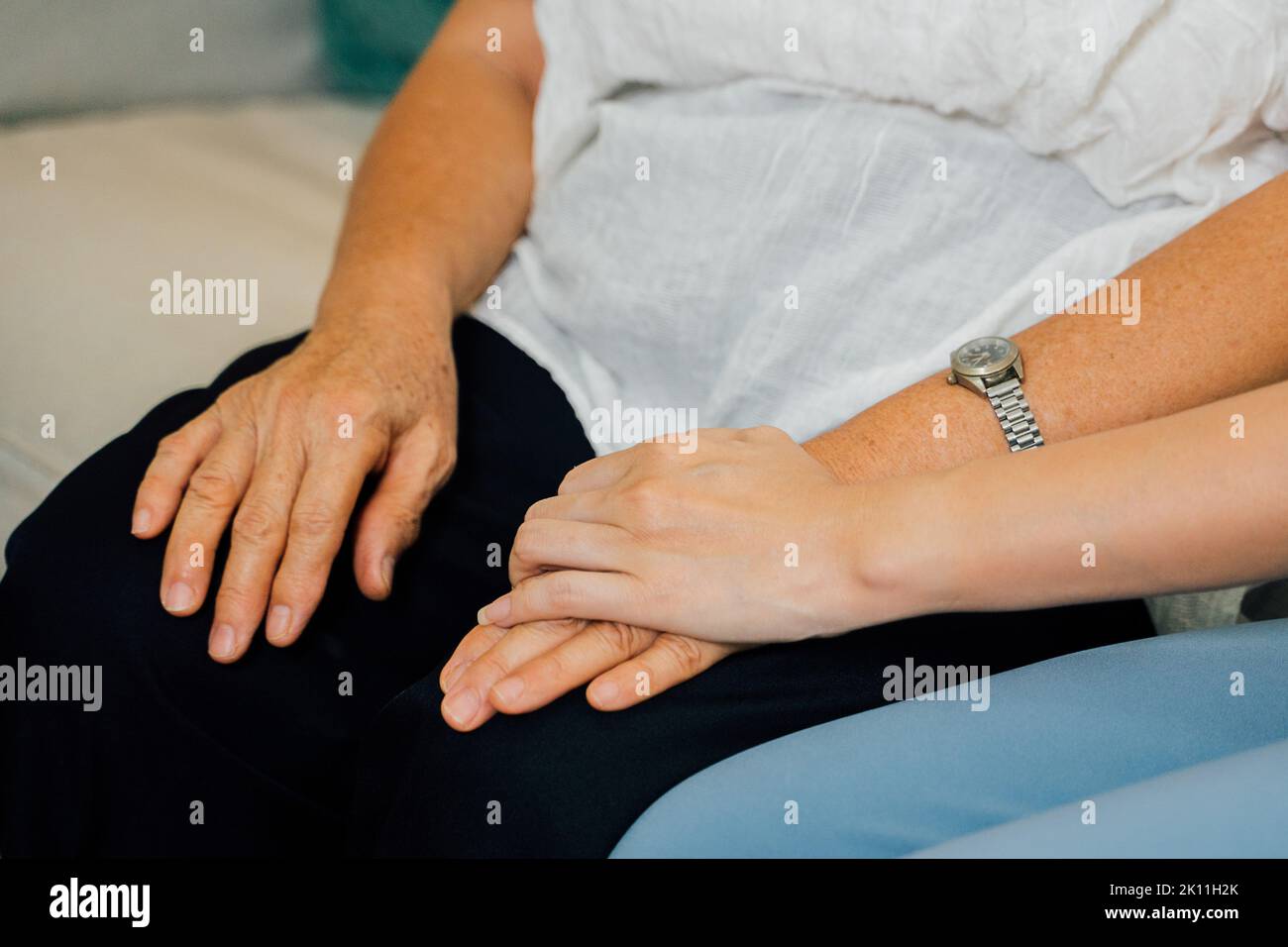 Nahaufnahme der Hände, die zwischen zwei Generationen von Frauen halten. Mutter und Tochter halten sich die Hände. Stockfoto