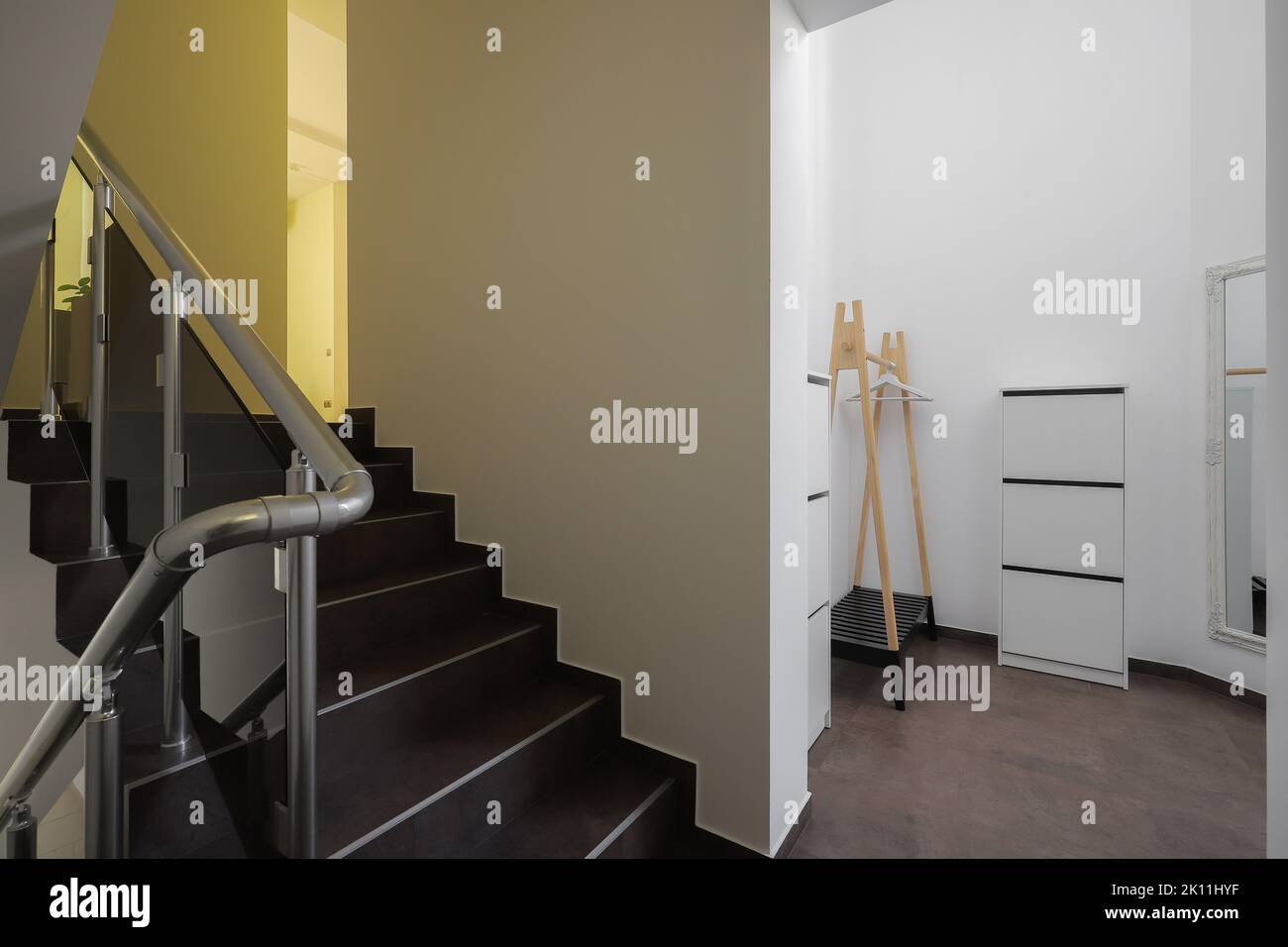 Treppe mit braunen Fliesen und hellen Wänden im Inneren des Hauses Stockfoto