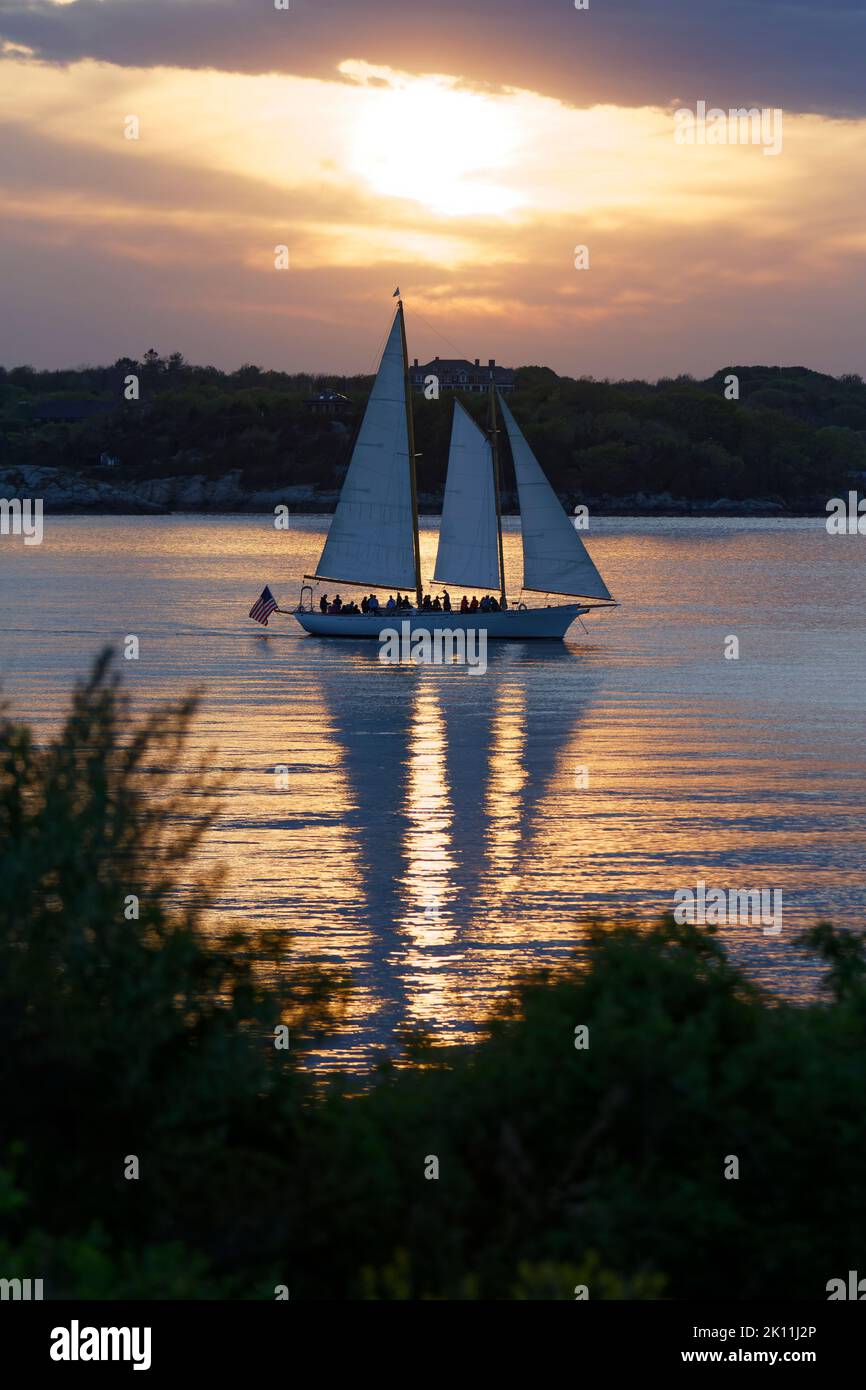 Boot, das bei einem wunderschönen Sonnenuntergang durch Wolken vorbeifährt. Stockfoto