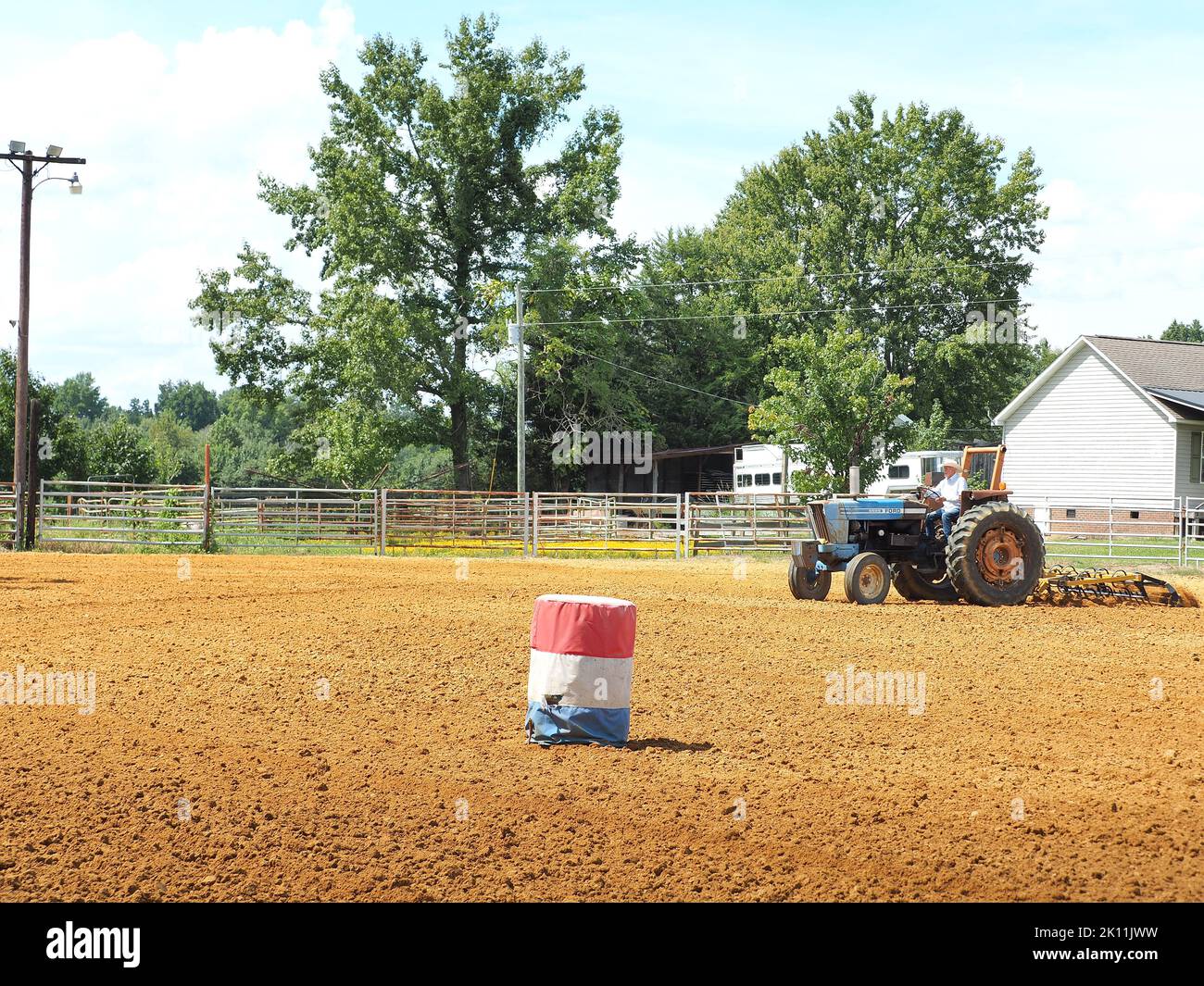 Traktor bereitet Sand für Barrel Racing vor Stockfoto
