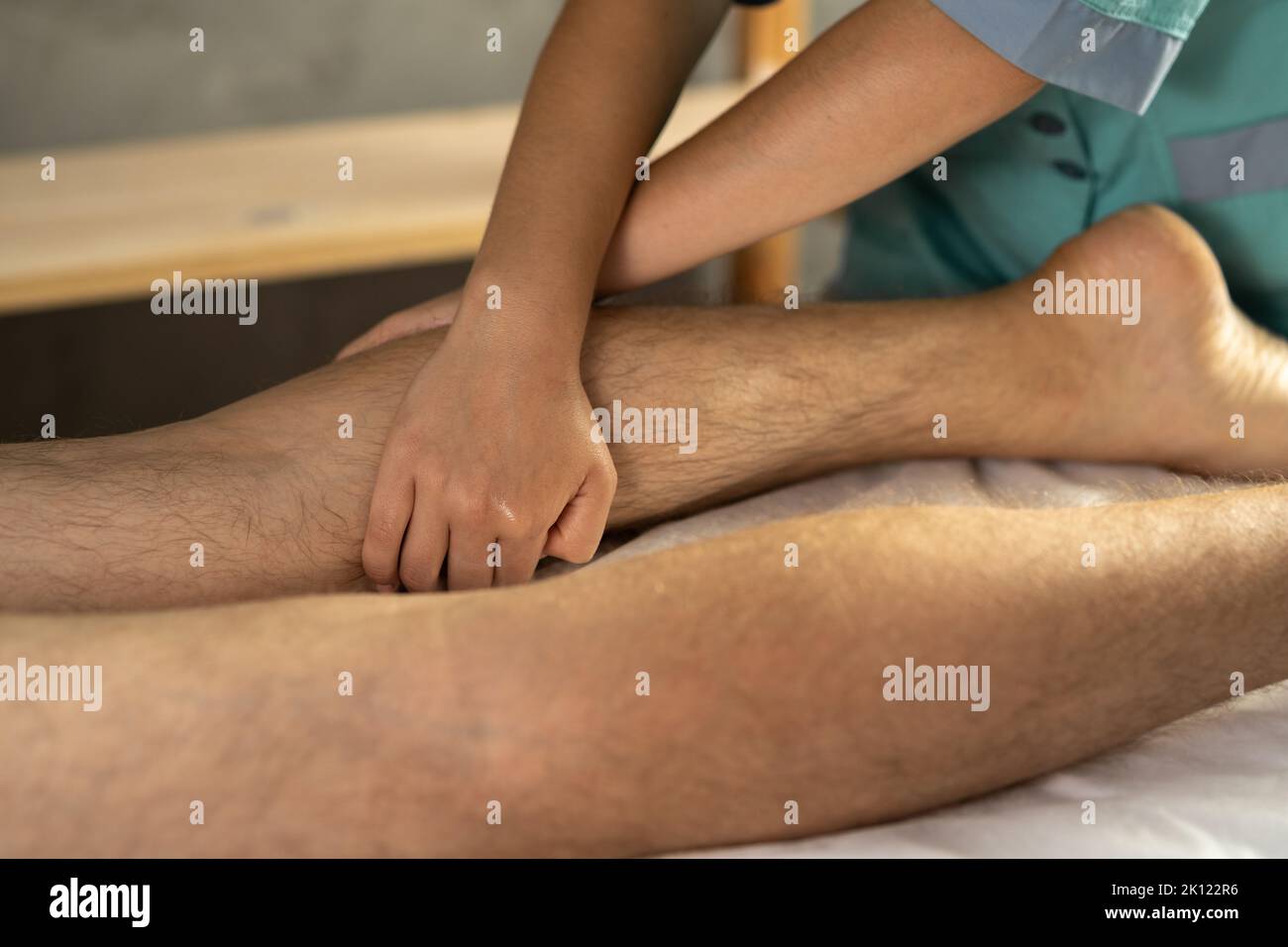 Sportmassage. Physiotherapeut massiert die Beine eines jungen männlichen Athleten. Therapeut bei einer Kalbsmassage Stockfoto