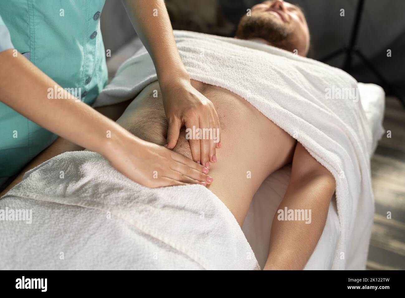 Professionelle Massage des Bauches. Mann erhält eine Magenmassage im Spa Stockfoto