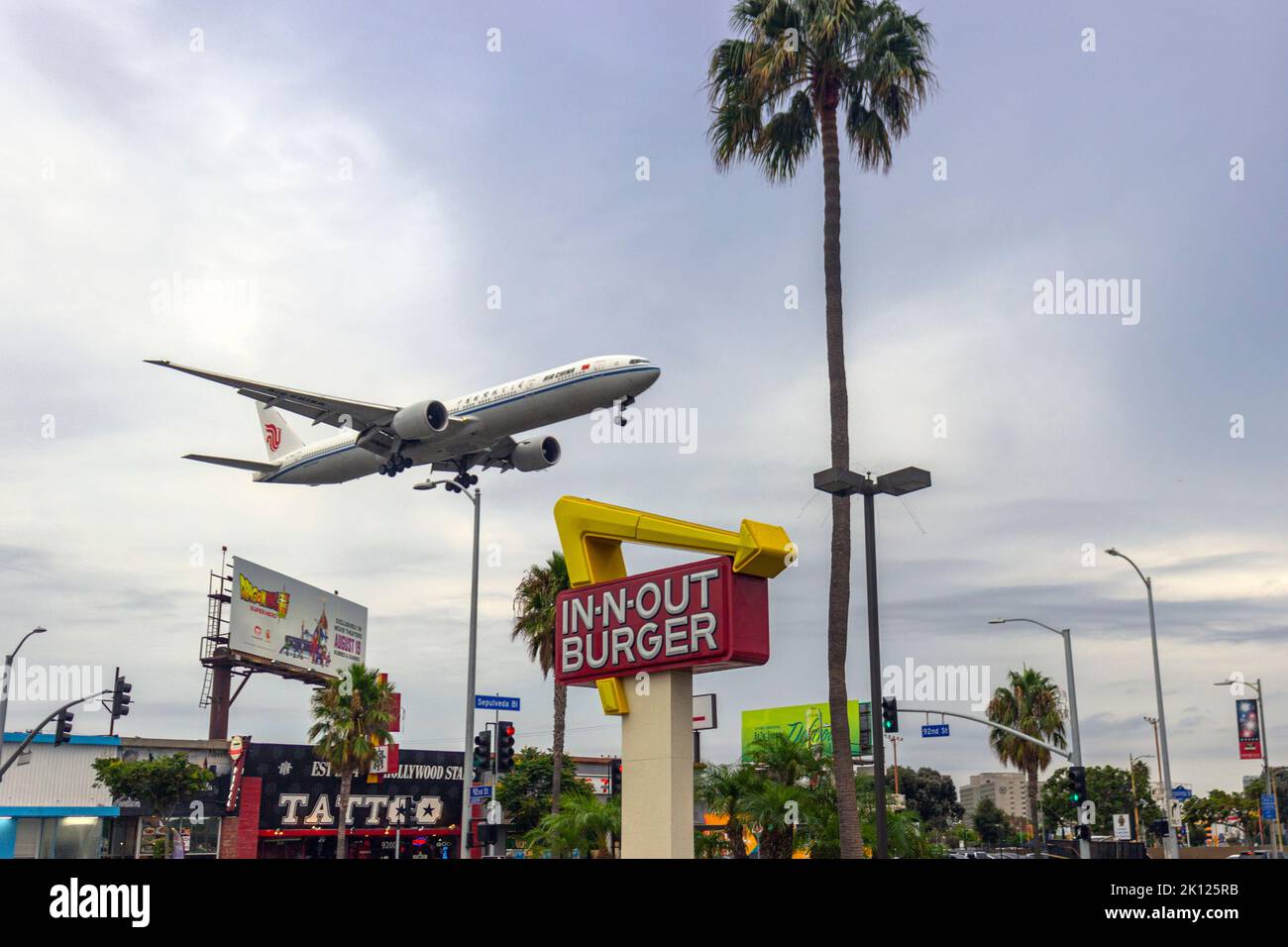 Air China Passagierjet, der in N Out Burger auf dem Sepulveda Blvd überfliegt, bevor er am 10. September 2022 am 25R am LAX landet Stockfoto