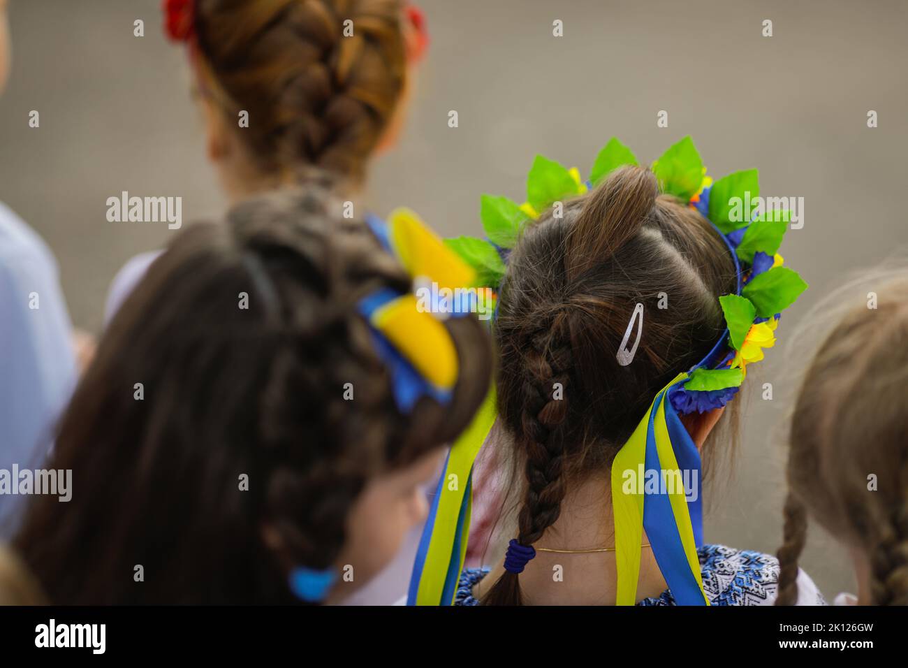 Details zur geringen Schärfentiefe (selektiver Fokus) mit dem ukrainischen Flaggenband im Haar eines Schulmädchen. Stockfoto