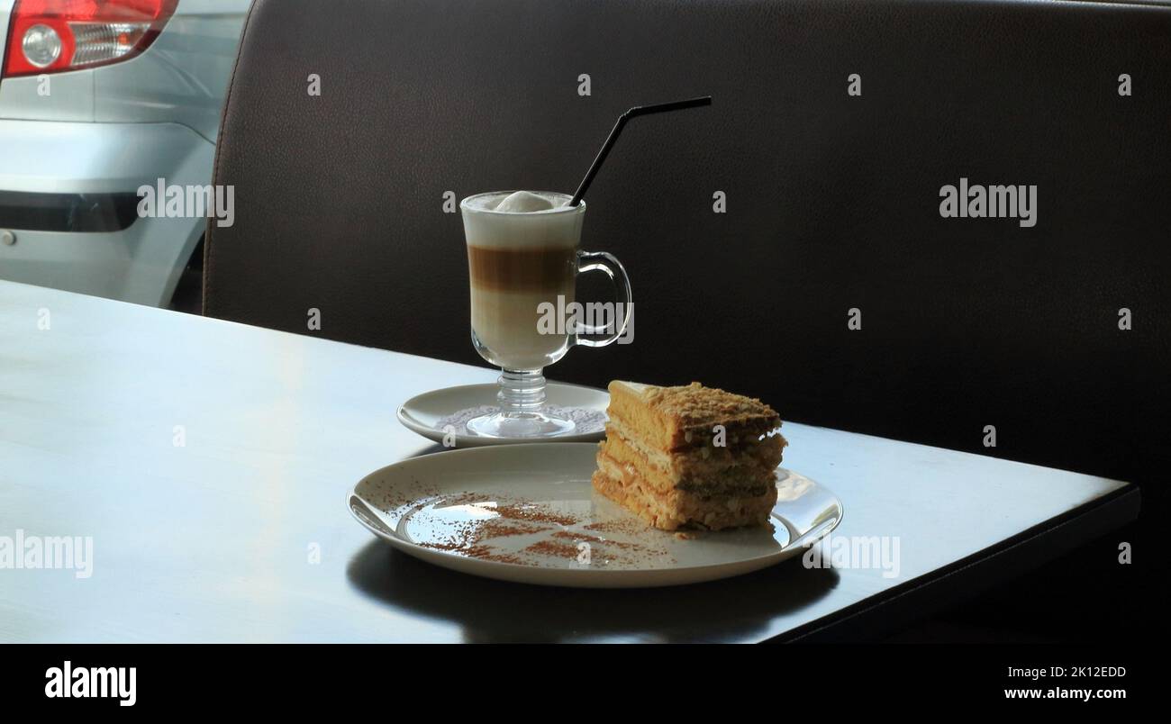 Blätterteigkuchen und Rahmkaffee auf dem Tisch an der Snackbar an der Tankstelle Stockfoto