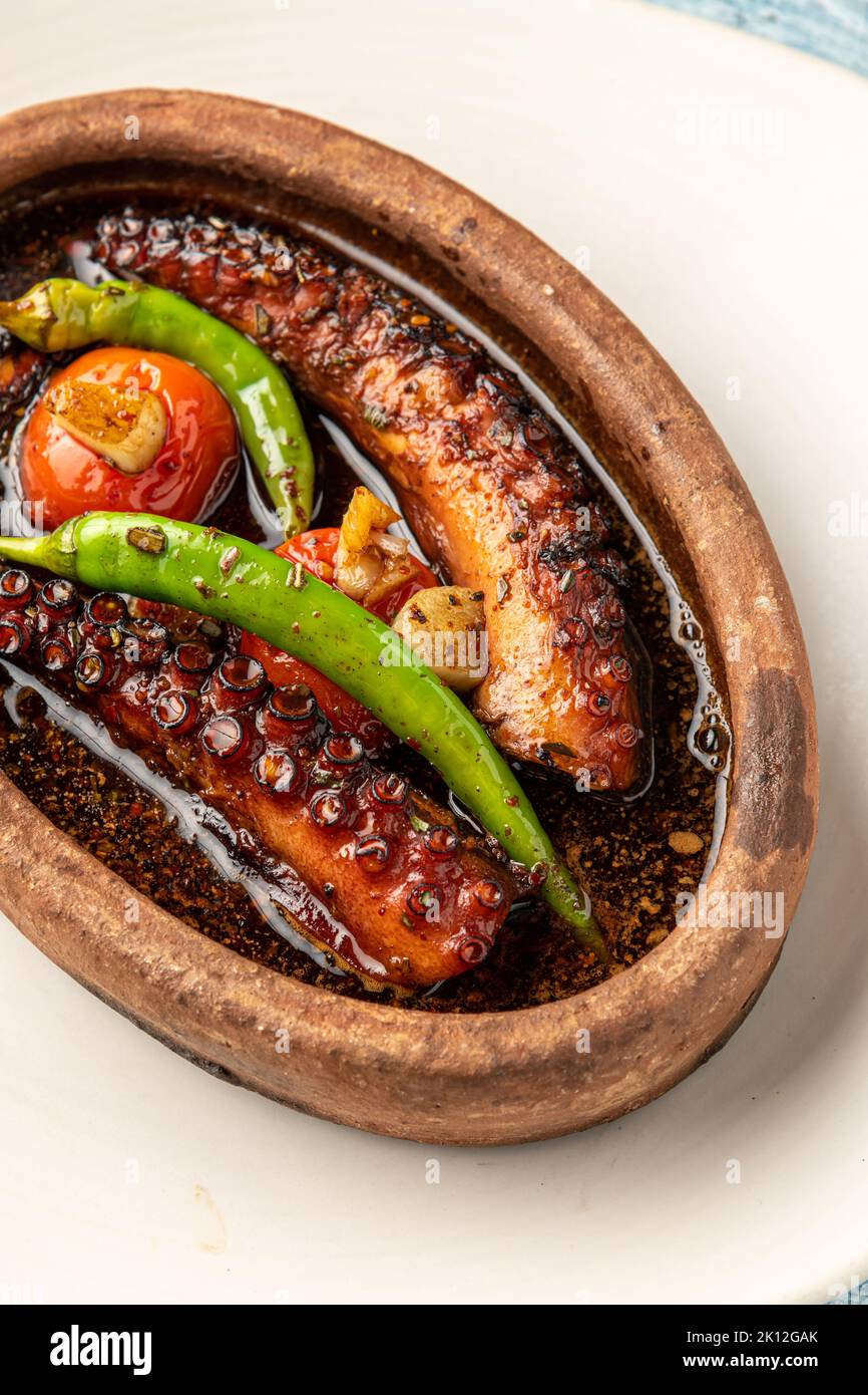 Kasserolle Tintenfisch mit Tomaten und Paprika auf blauem Stein Hintergrund Stockfoto