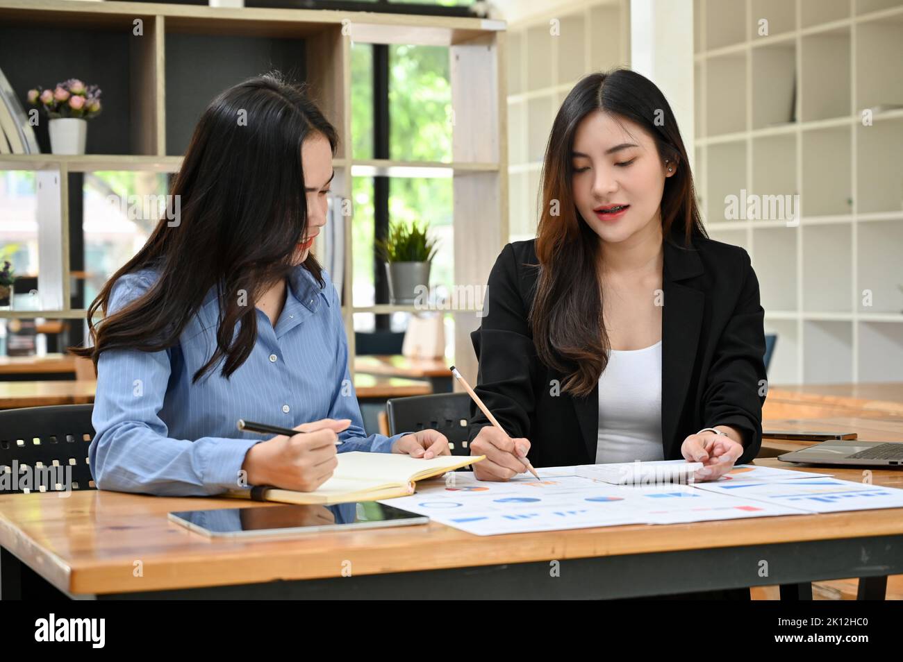 Professionelle und schöne junge asiatische Geschäftsfrau oder Finanzmanagerin, die ihr neues Personal im Büro ausbilden kann. Stockfoto