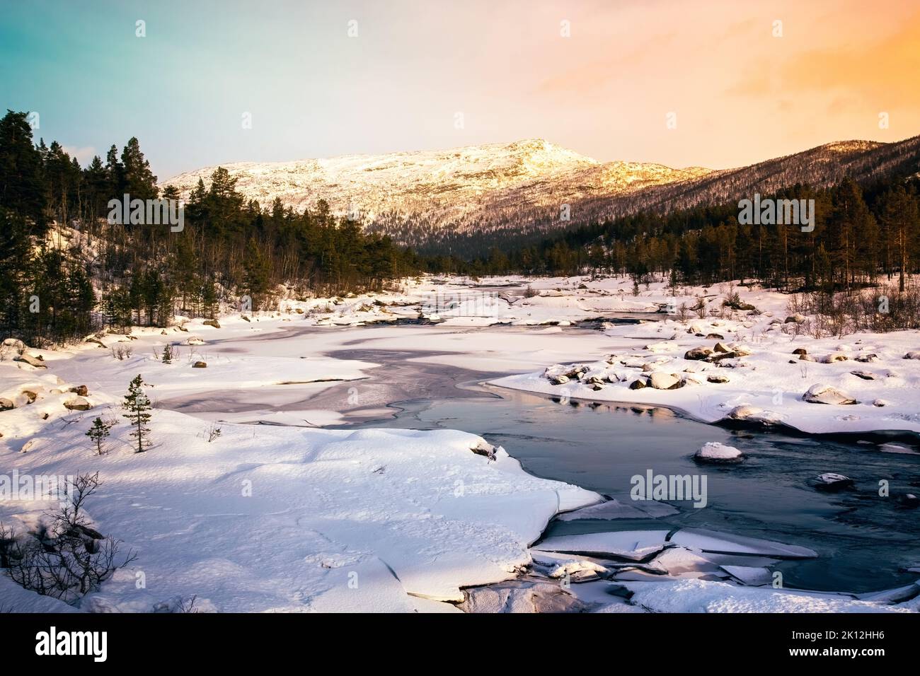 Gefrorener Fluss im magischen norwegischen Setesdal im Winter bei Sonnenuntergang. Stockfoto